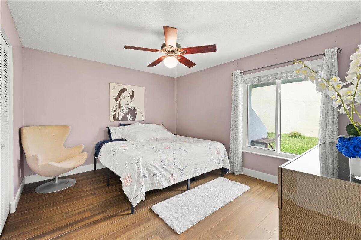 Wood-finish flooring, multi-pane window, and central ceiling fan with integrated lighting