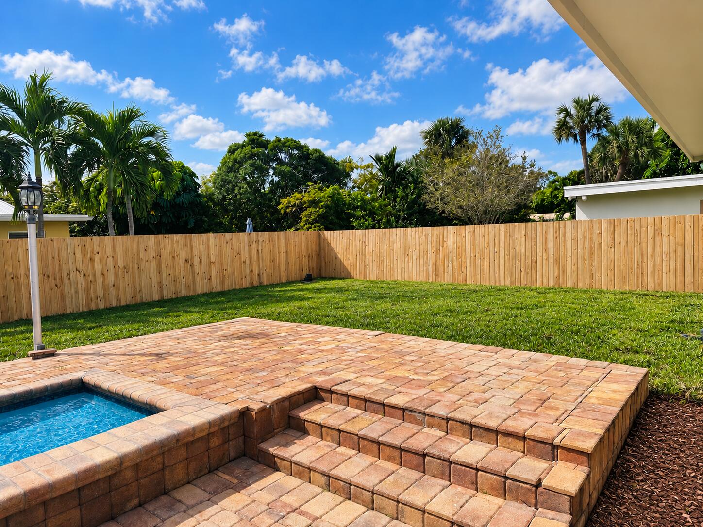 Sunlit Poolside Patio with Mulch Bed