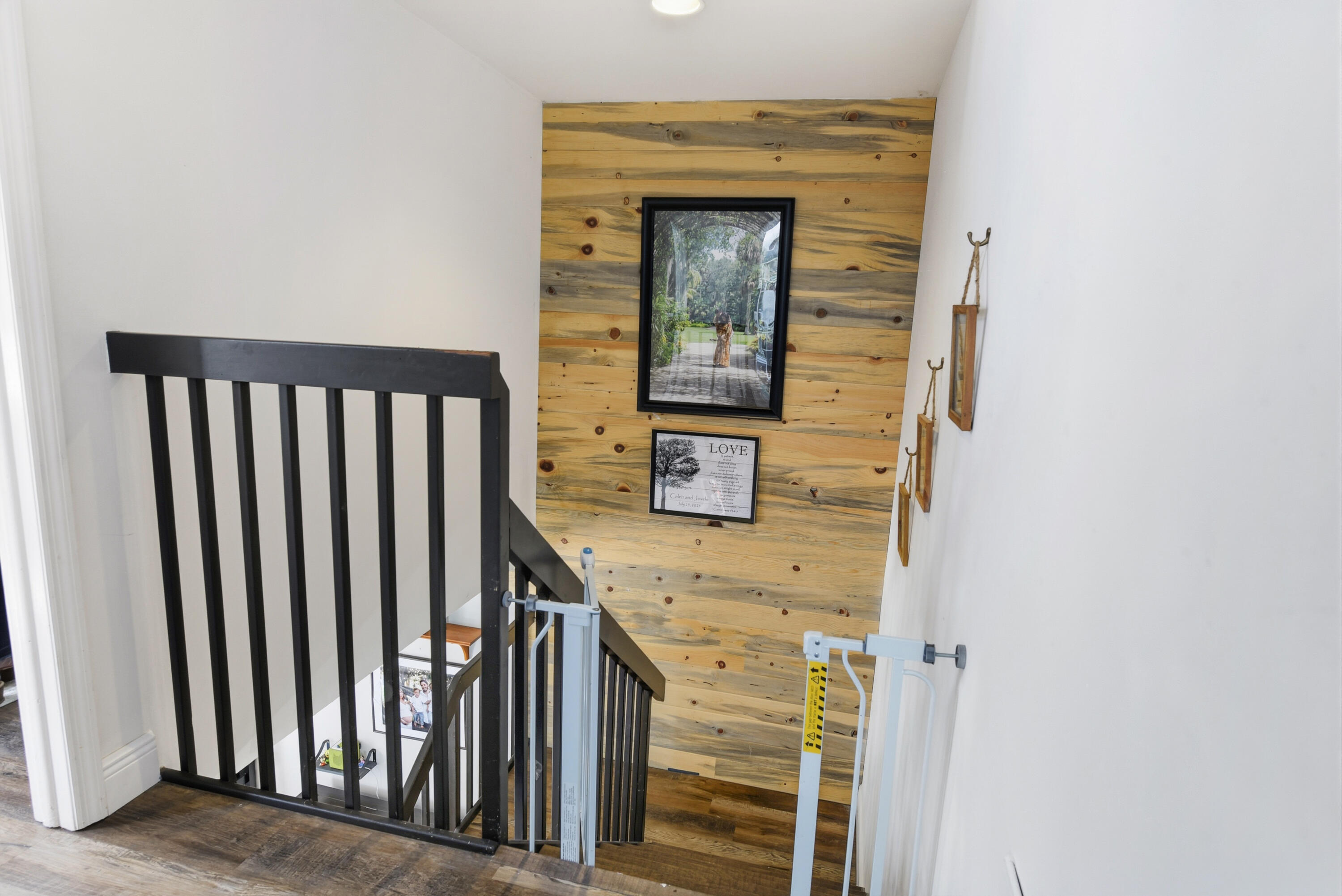 Staircase featuring horizontal wood-plank accent wall and dark-finished wooden balusters