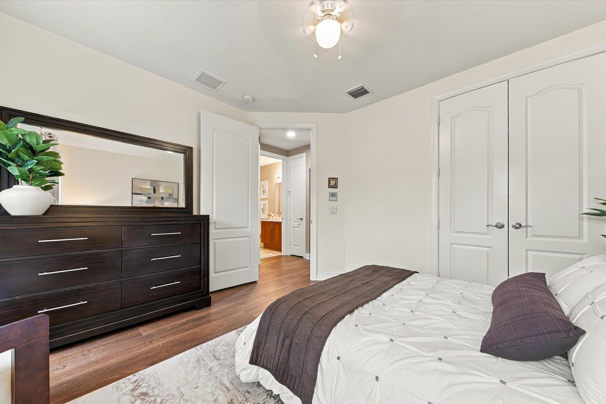 Neutral interior featuring wood-finish flooring, white paneled doors, and a central ceiling fan with integrated lighting
