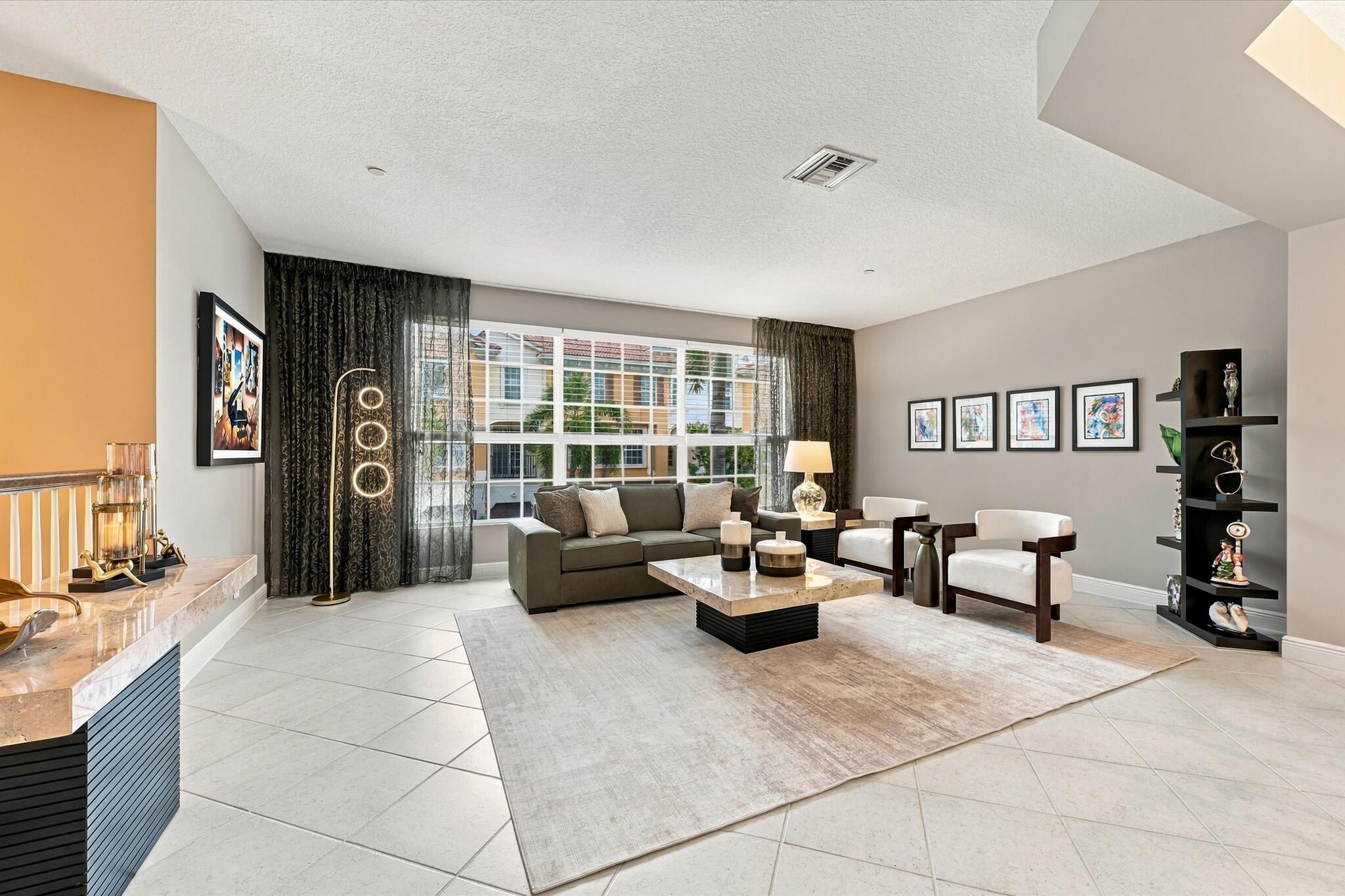 Spacious room featuring light-colored tile flooring, oversized multi-pane windows, neutral wall paint, and a built-in counter surface with stone detailing