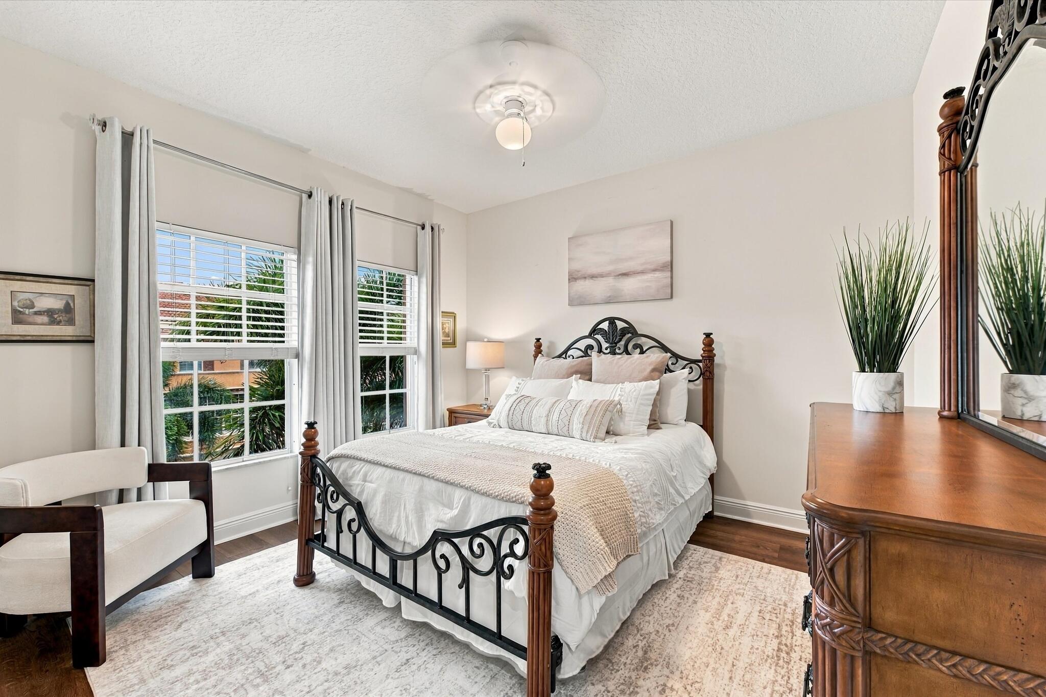 Wood-finish flooring, dual windows with grid detailing, and central overhead lighting fixture