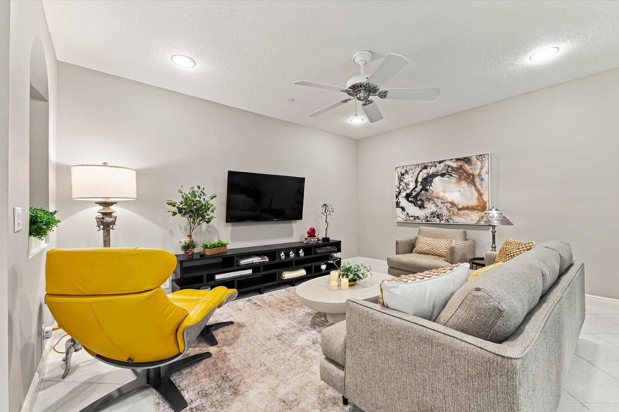 Neutral-toned interior featuring recessed lighting, a ceiling fan with integrated lighting, tiled flooring, and an arched wall niche