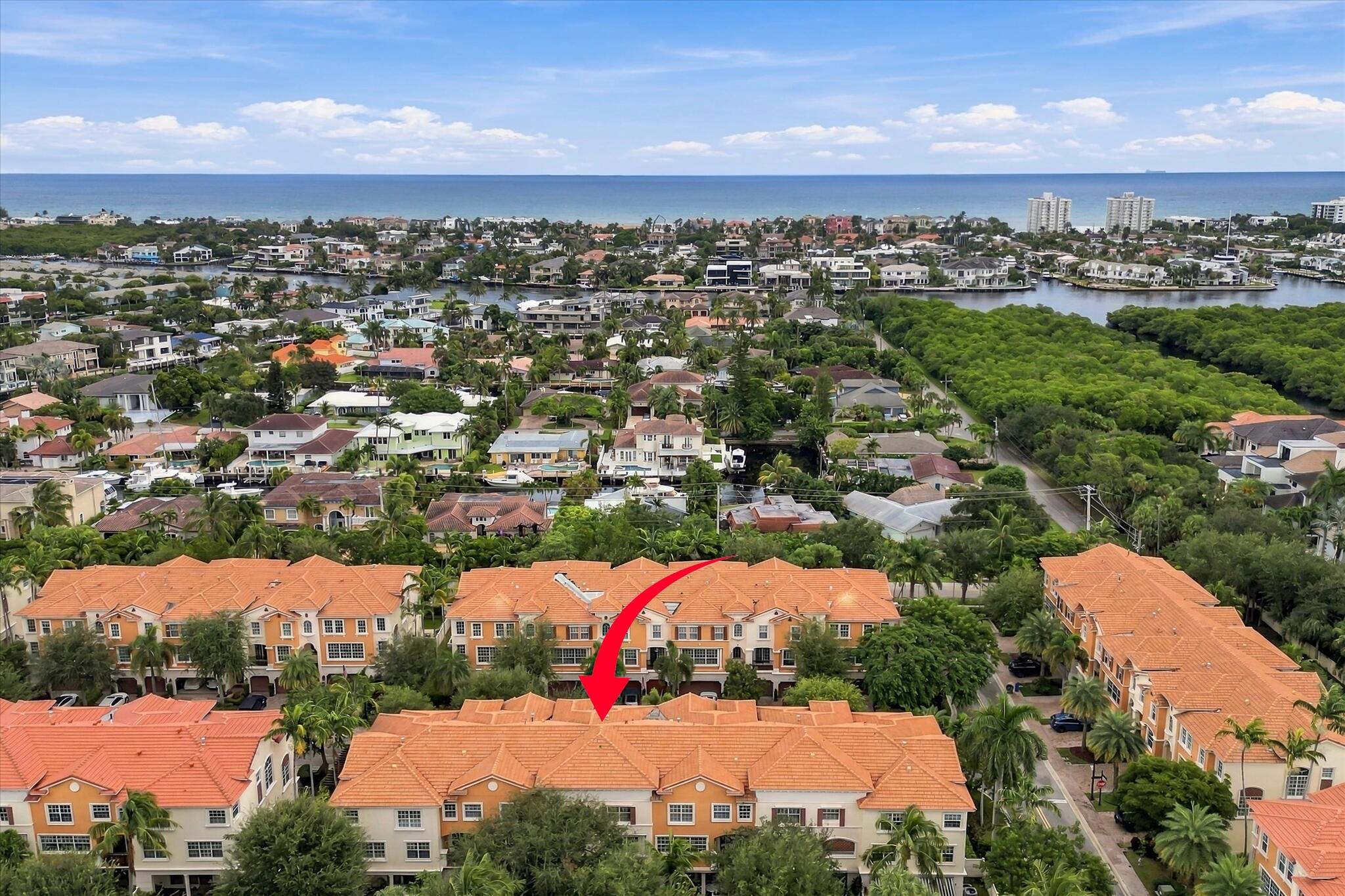 Aerial perspective of a multi-story residential complex featuring terracotta-tiled rooflines and cream-colored exterior facades