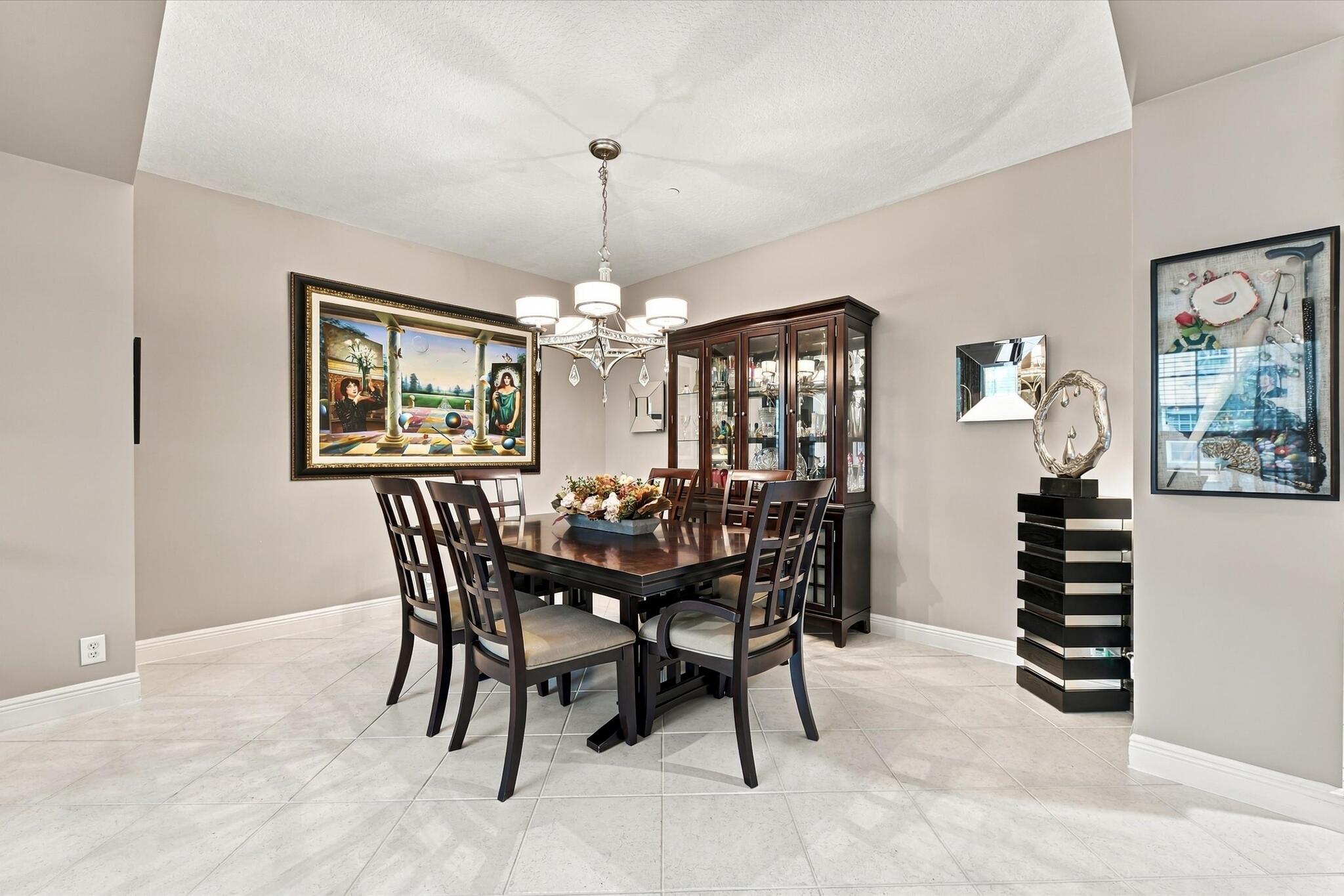 Dining area featuring large-format diagonal tile flooring, a multi-arm chandelier with glass shades, and neutral wall tones