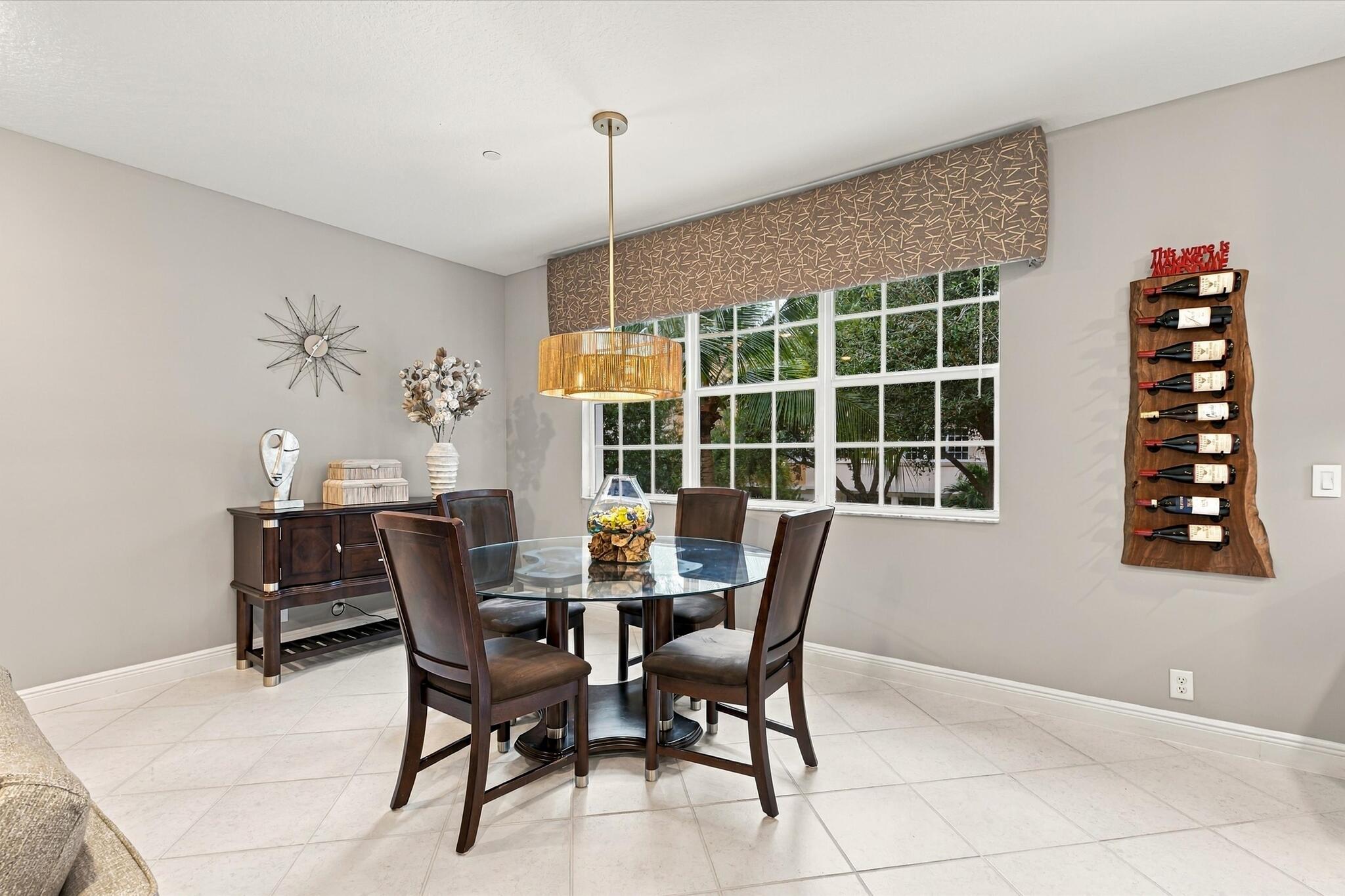 Ceramic tile flooring, large multi-pane windows, and a cylindrical metallic pendant light fixture