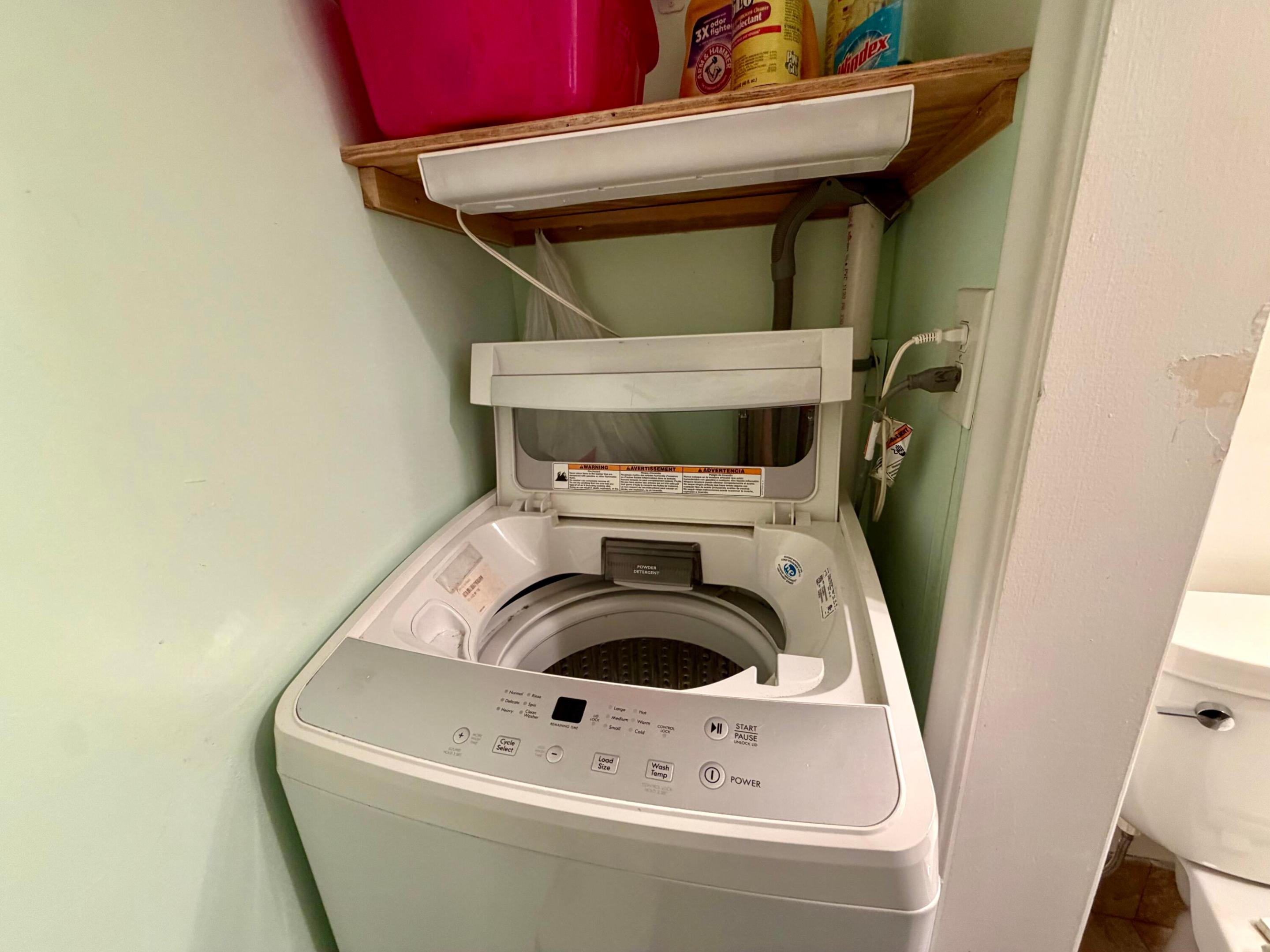 Top-loading washer with a digital control panel and built-in upper shelving