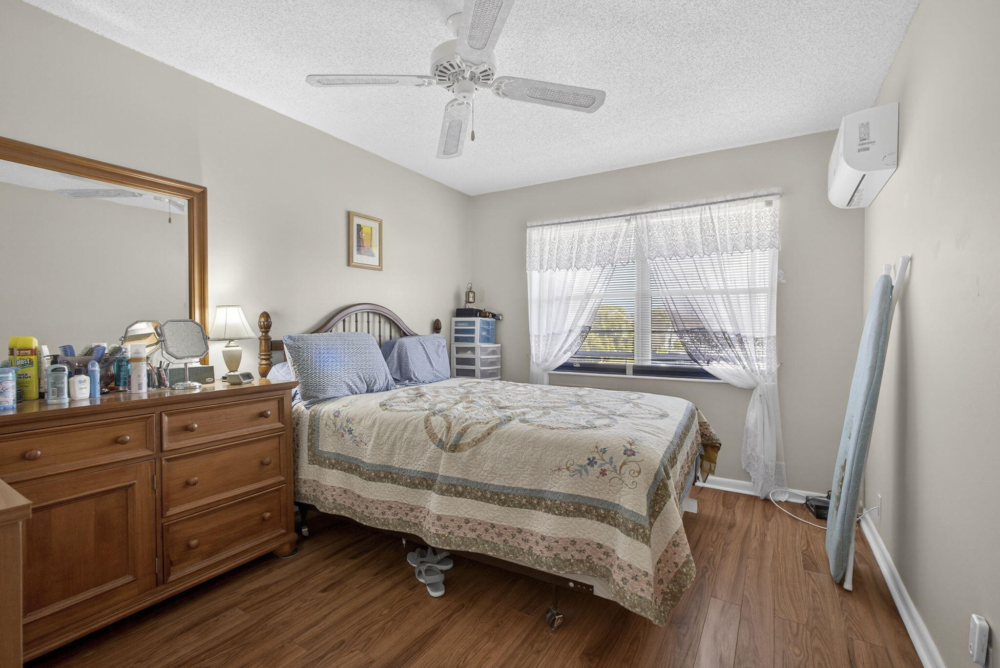 Wood-finish flooring, wall-mounted climate control unit, ceiling fan, and multi-pane window