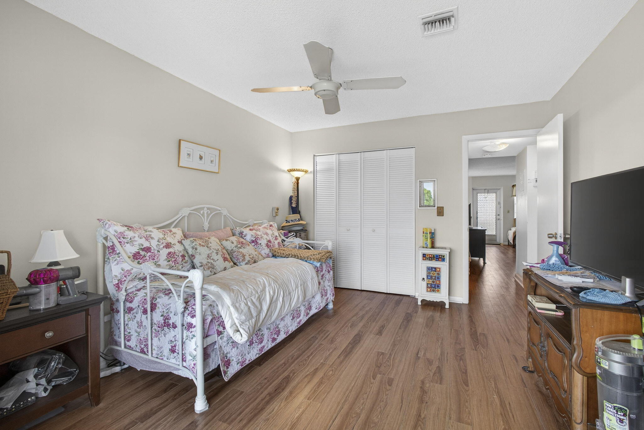 Wood-finish flooring, ceiling fan, and floor-to-ceiling bi-fold closet doors