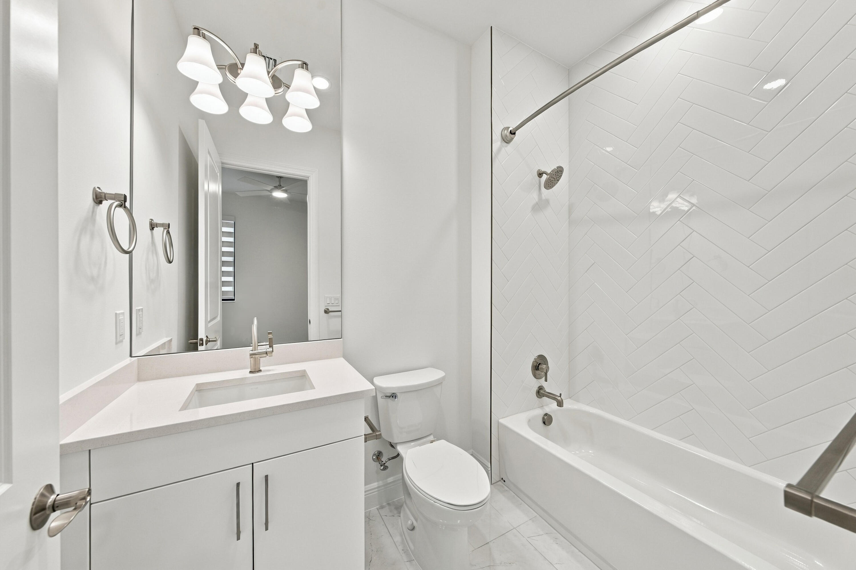 2nd bathroom with upgraded countertop, cabinets, tub/shower with tile and mirror to the ceiling