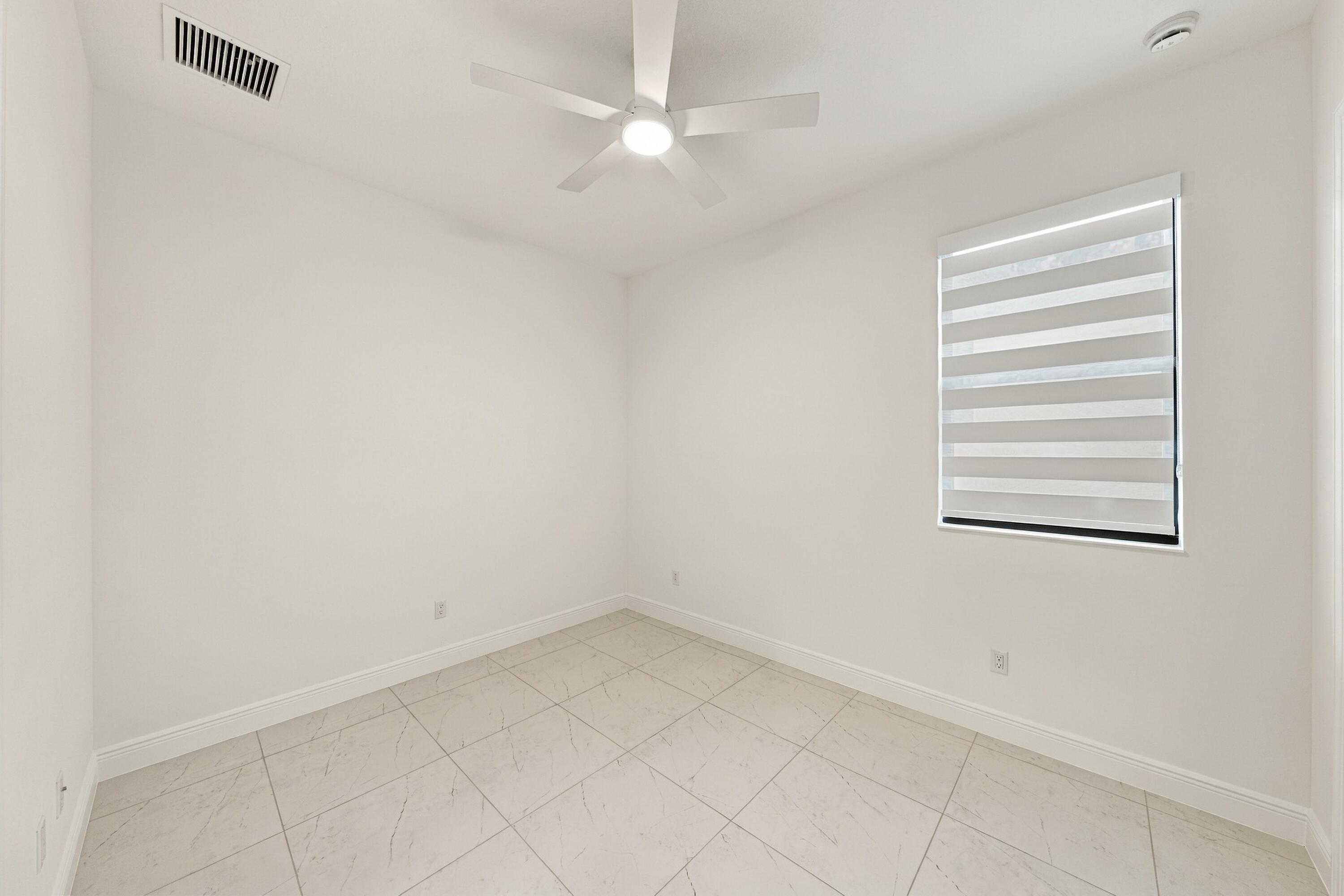 2nd bedroom with en-suite bathroom zebra blinds and ceiling fan