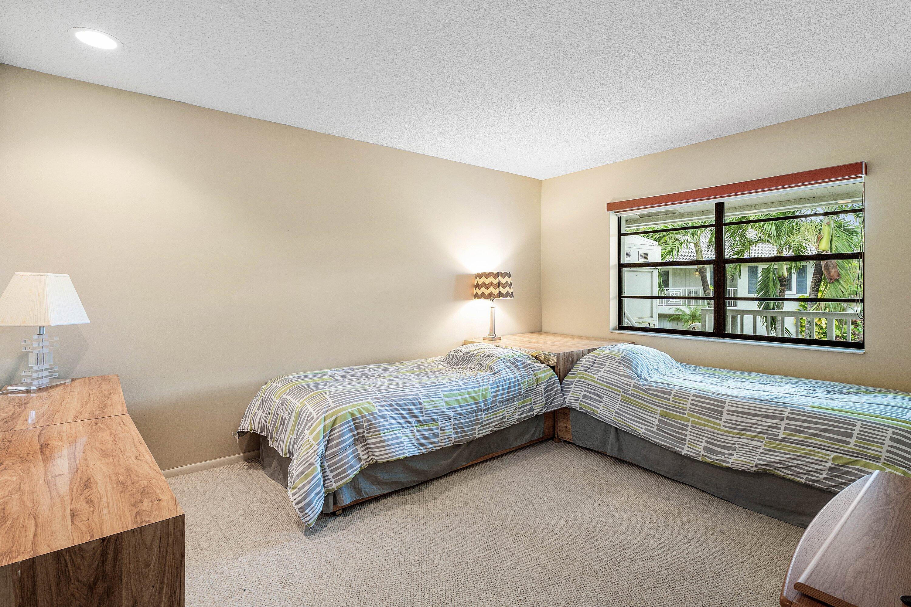 Neutral-toned interior room featuring wall-to-wall carpeting, a multi-pane window with black framing, and recessed ceiling lighting