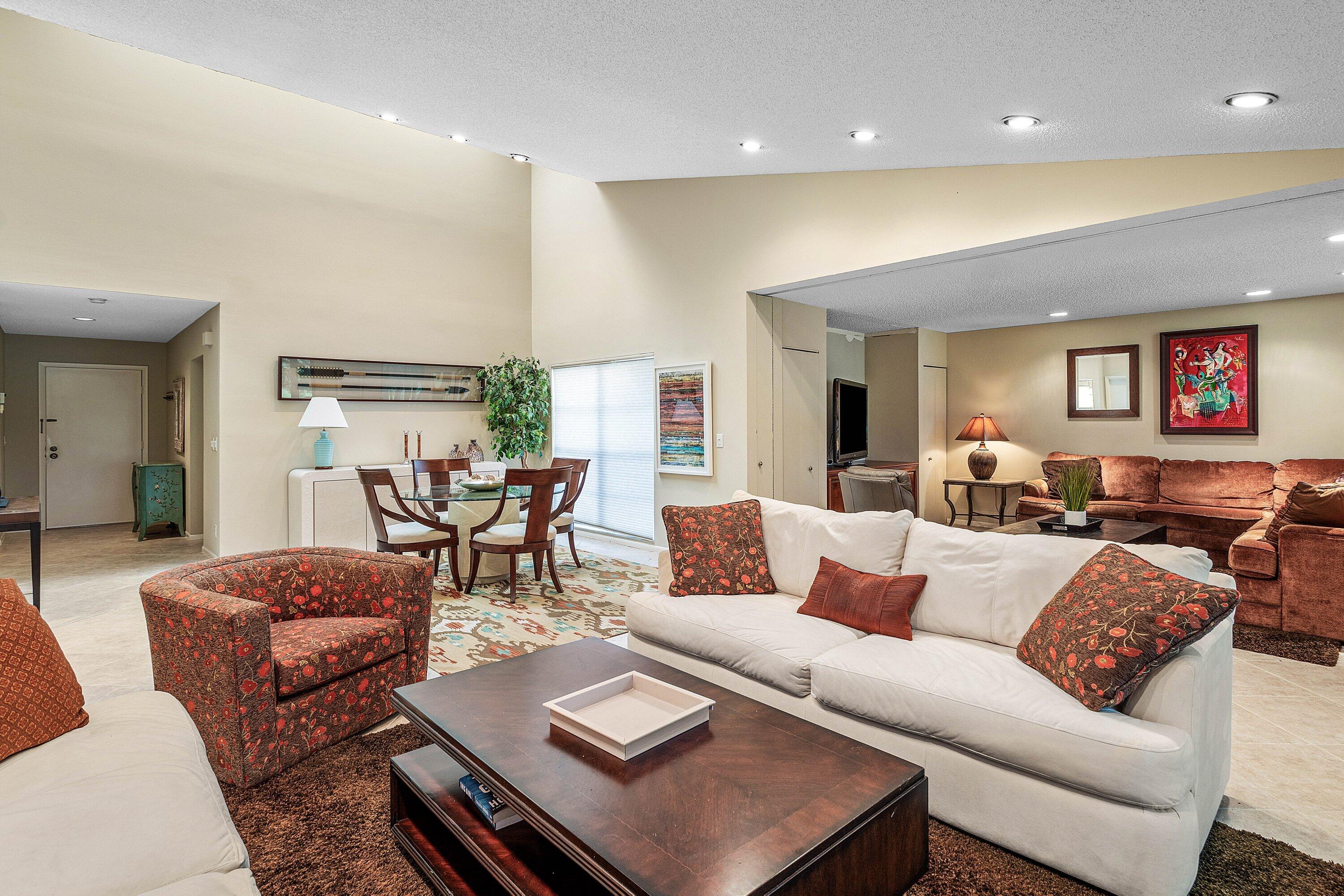 Expansive living area featuring soaring vaulted ceilings, recessed lighting, and tile flooring