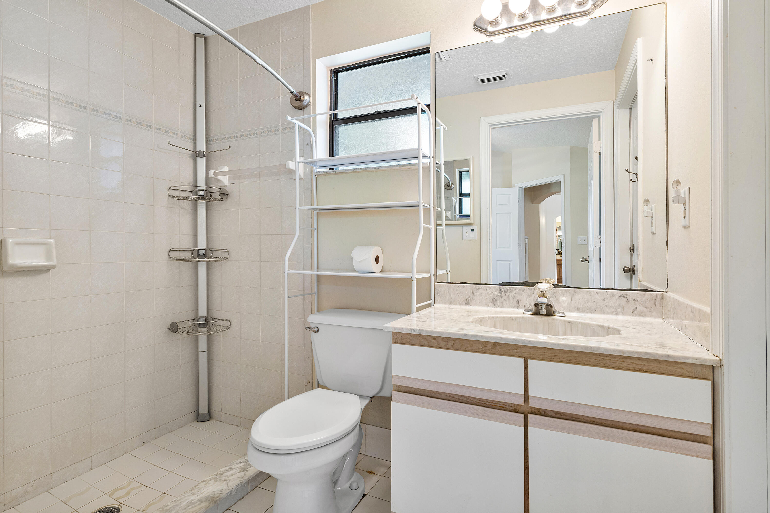 Primary bathroom ensuite number two featuring a vanity with a stone-top counter, undermount sink, and full-width vanity mirror
