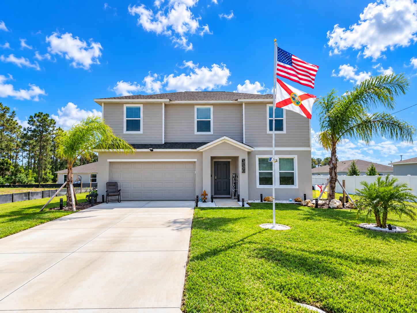 Sunny Suburban Home with Flags and Palms