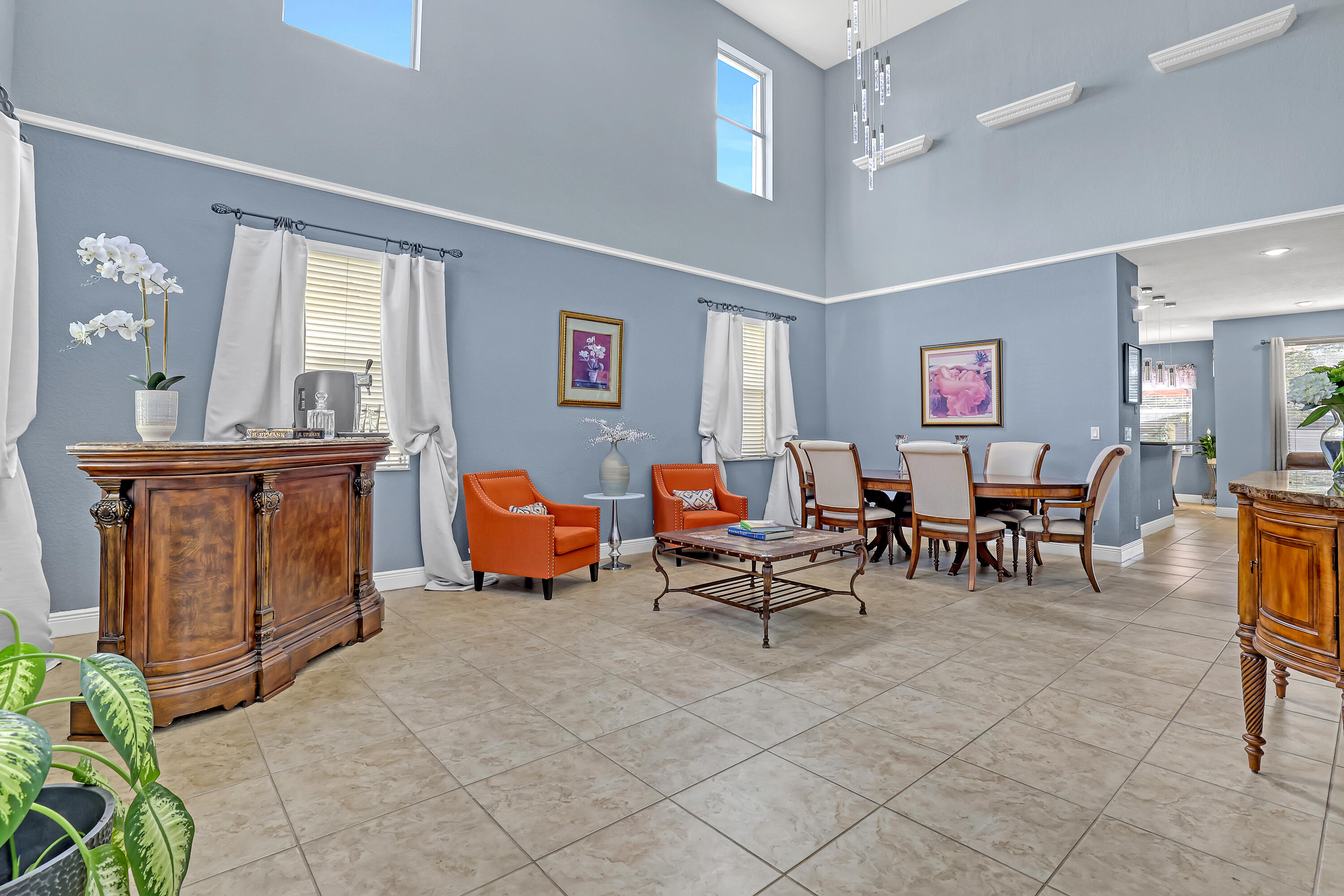 Double-height ceilings featuring transom windows, tile flooring, and a multi-light pendant chandelier Double-height ceilings featuring transom windows, tile flooring, and a multi-light pendant chandelier