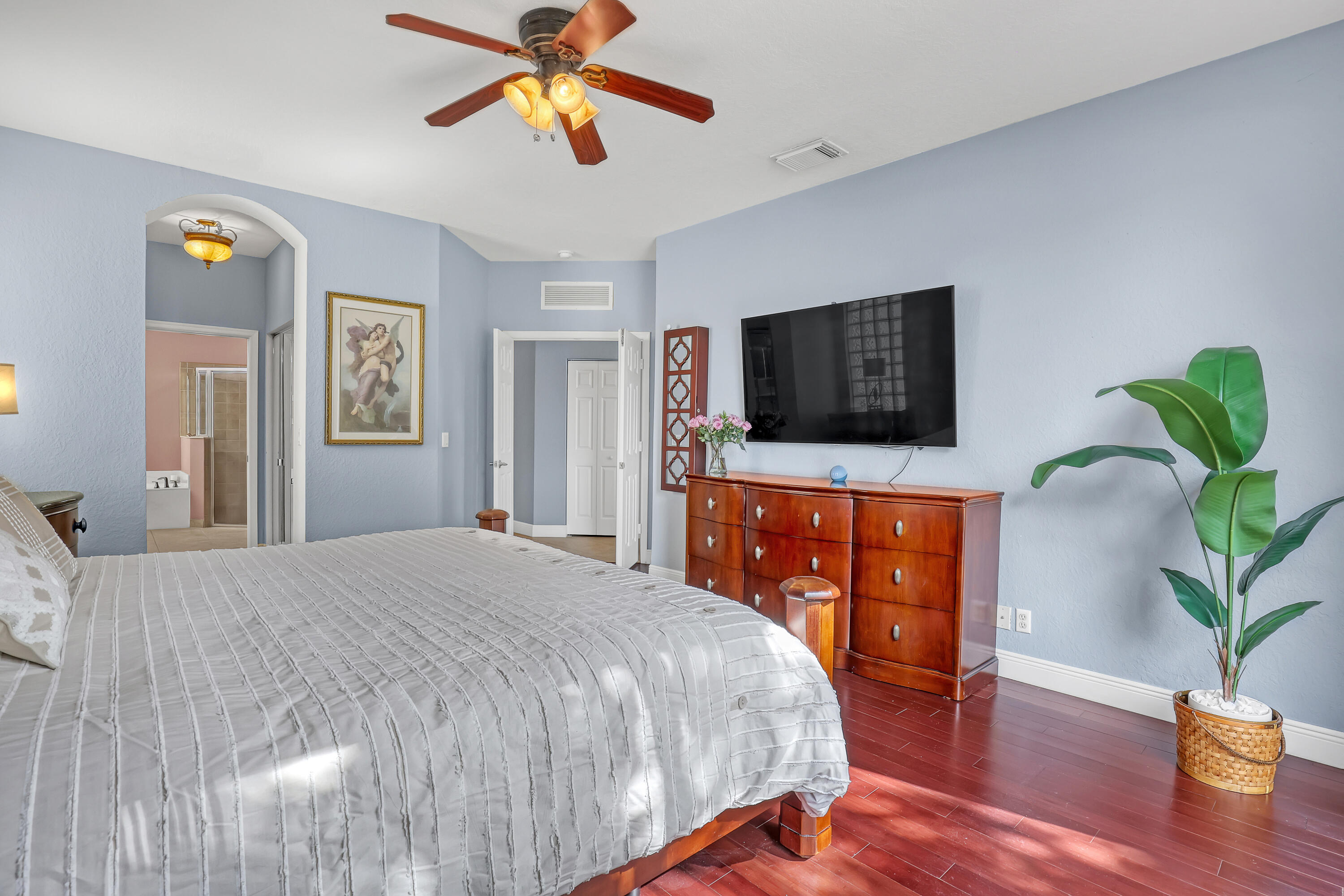 Room featuring dark wood-finish flooring, vaulted ceiling with a multi-blade light fixture