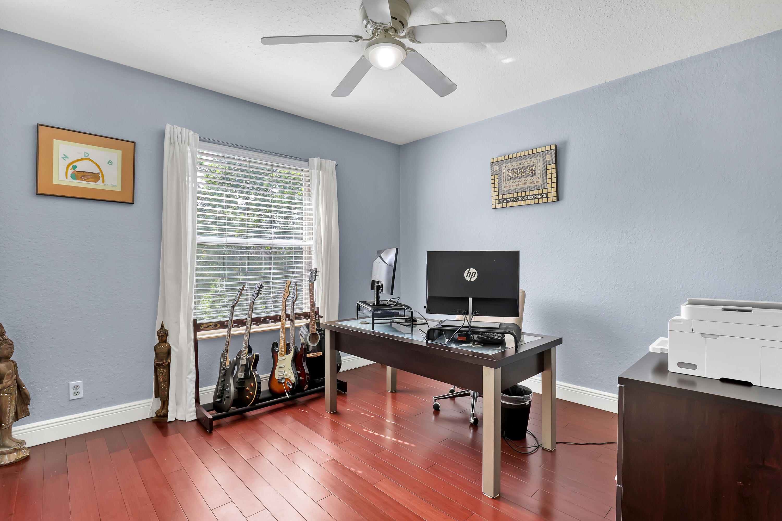 Room featuring wood-finish flooring, a neutral wall finish, and a ceiling fan with integrated lighting