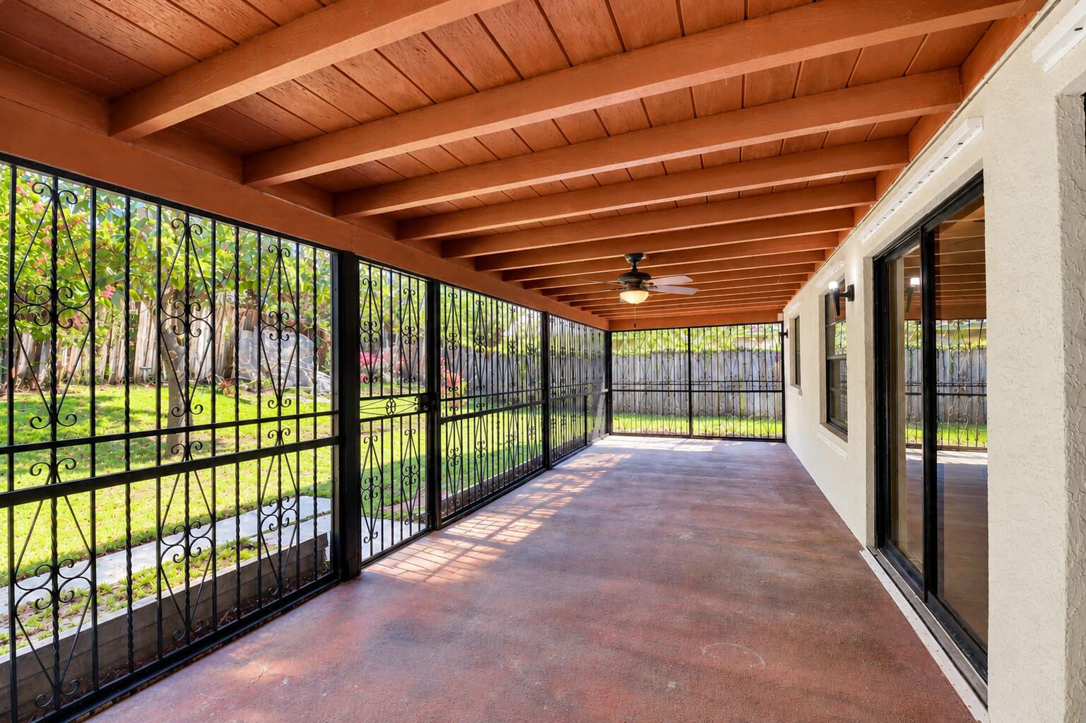 Expansive Covered Patio with Exposed Wood-Beam Ceiling, Ceiling Fan & Garden Views