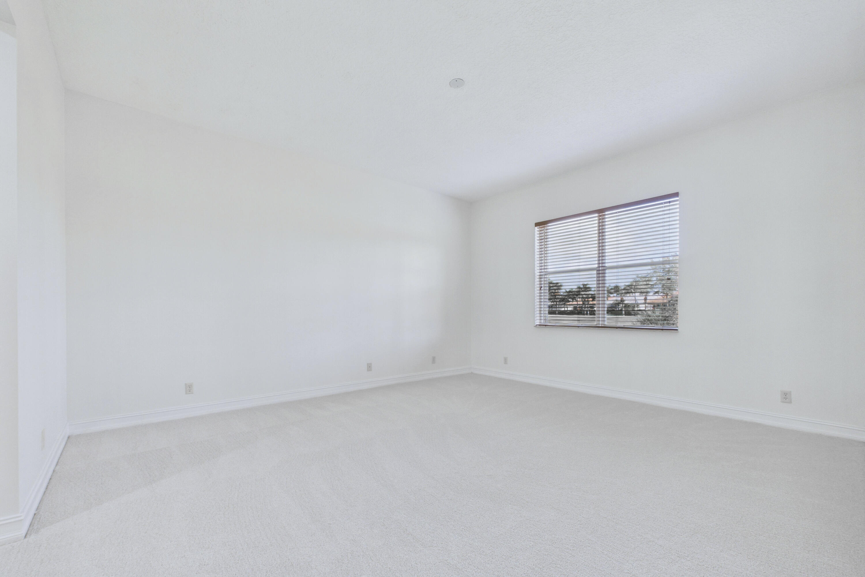 Fresh and clean primary bedroom with freshly-painted walls and new carpeting