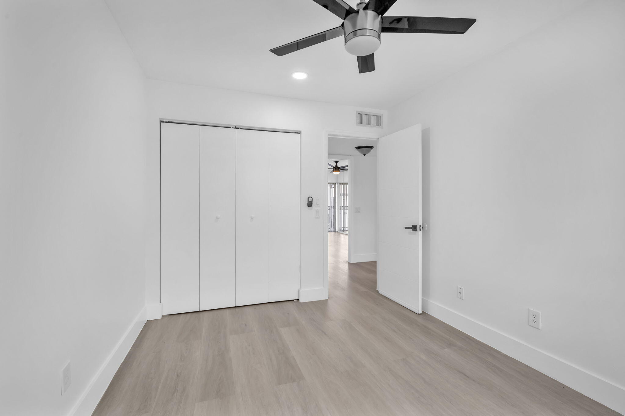 Room featuring wood-finish flooring, recessed lighting, a modern ceiling fan with integrated light, and a four-panel closet door