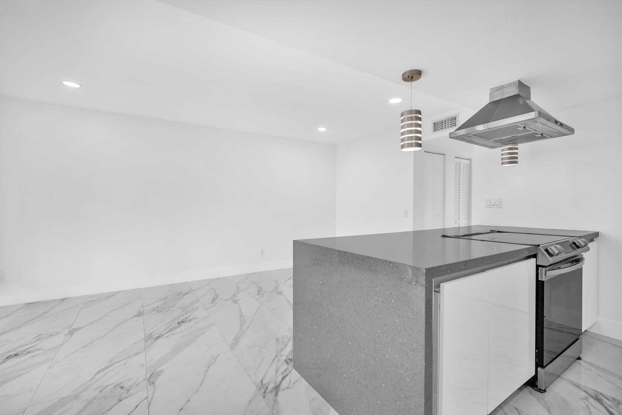 Kitchen featuring a central island with a solid surface countertop, high-gloss white cabinetry, stainless steel range, ceiling-mounted stainless steel vent hood, and large-format veined tile flooring