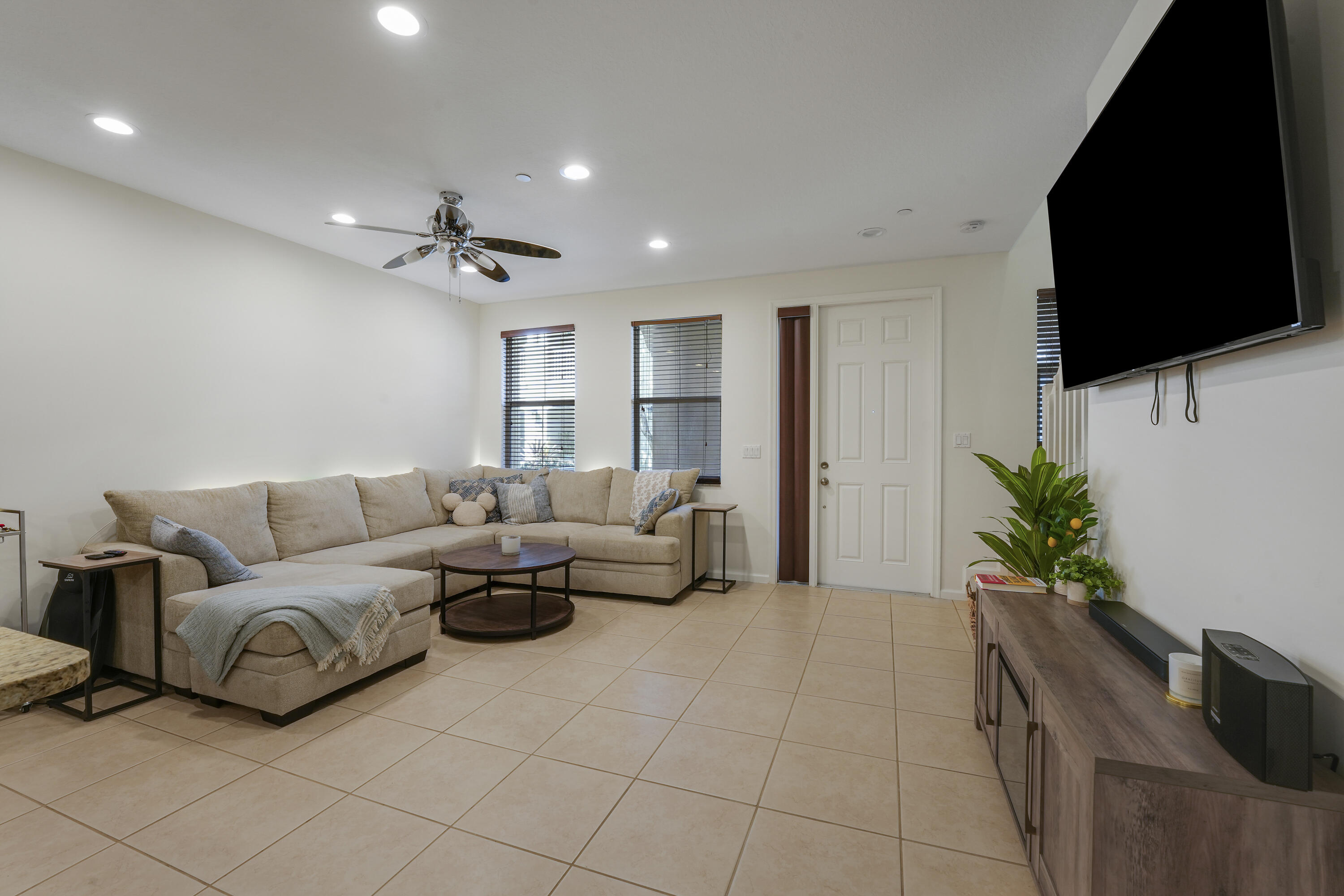 Neutral tile flooring, recessed lighting, and a ceiling fan with integrated lighting