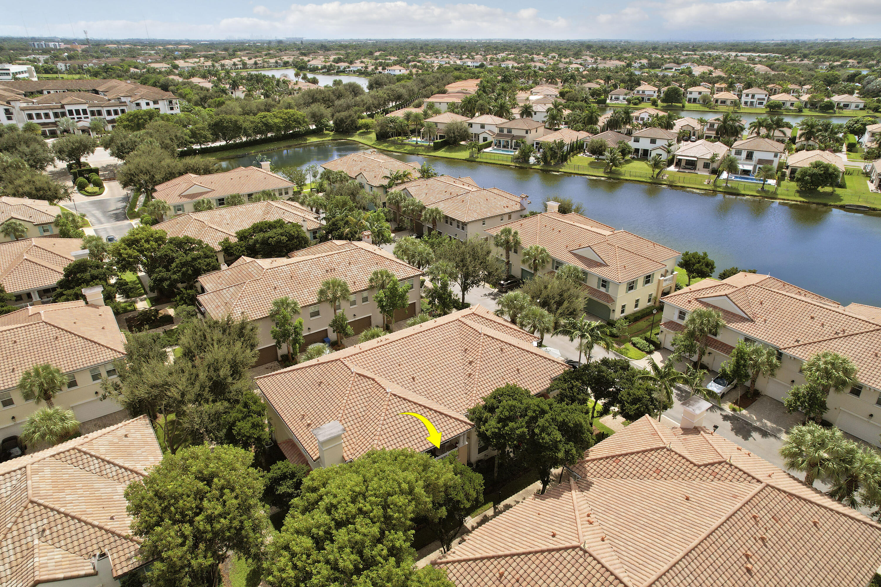 Aerial perspective of residential property featuring a tiled roof, exterior chimney, and mature landscaping Aerial perspective of residential property featuring a tiled roof, exterior chimney, and mature landscaping