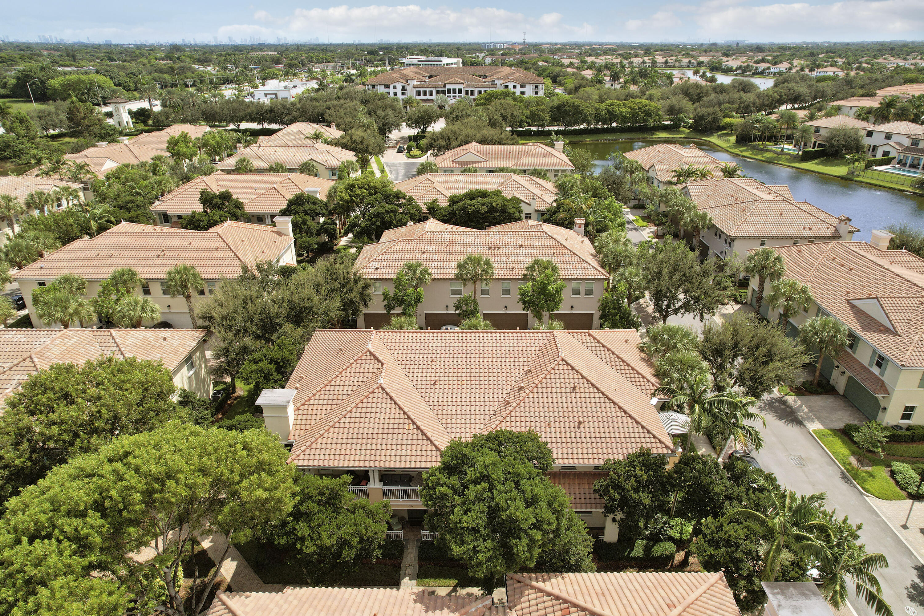 Aerial perspective of residential community featuring terra-cotta tile roofing, mature landscaping, and winding paved streets Aerial perspective of residential community featuring terra-cotta tile roofing, mature landscaping, and winding paved streets