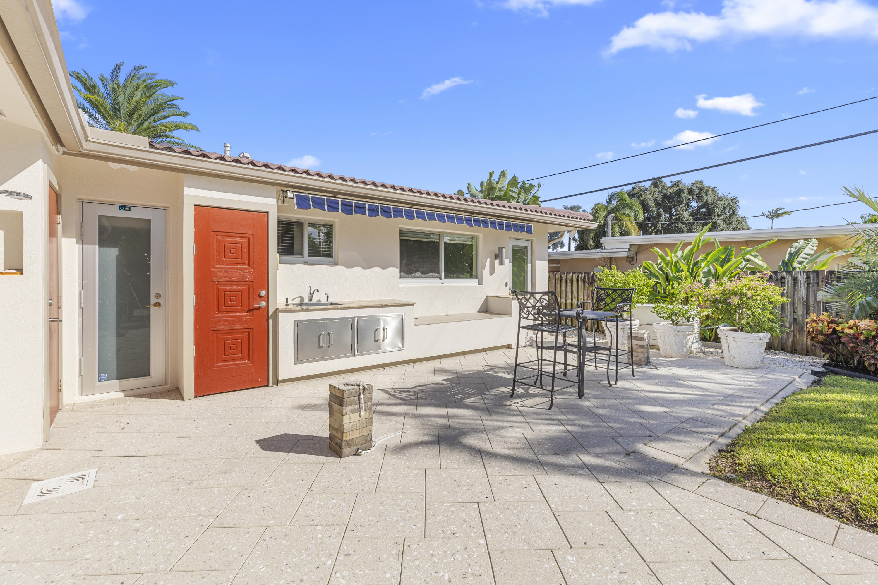 Outdoor patio featuring paver flooring, built-in stainless steel cabinetry, integrated sink, and retractable awning
