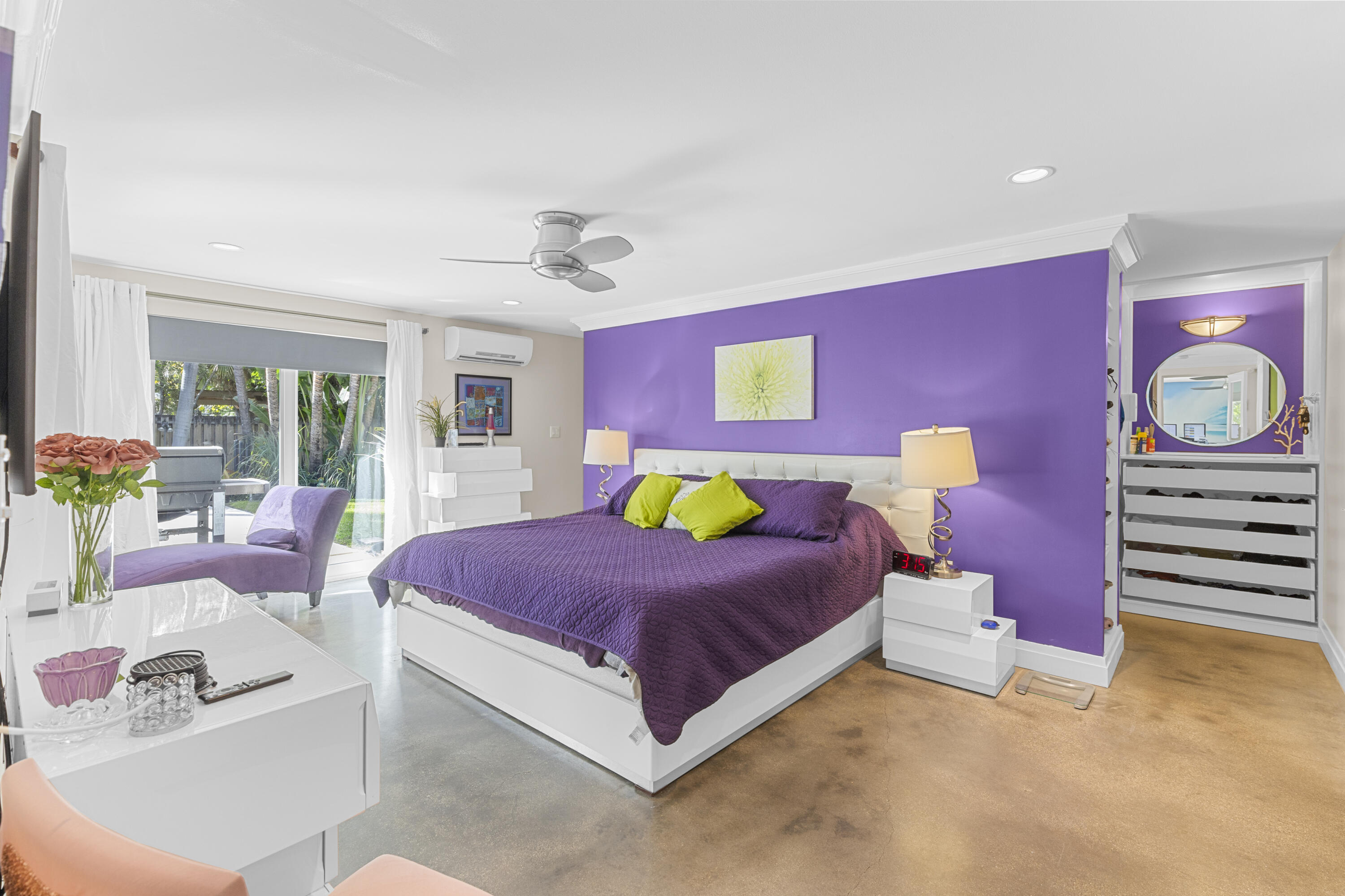 Bedroom featuring polished concrete flooring, a ceiling fan, recessed lighting, a wall-mounted climate control unit, and built-in shelving with an integrated mirror