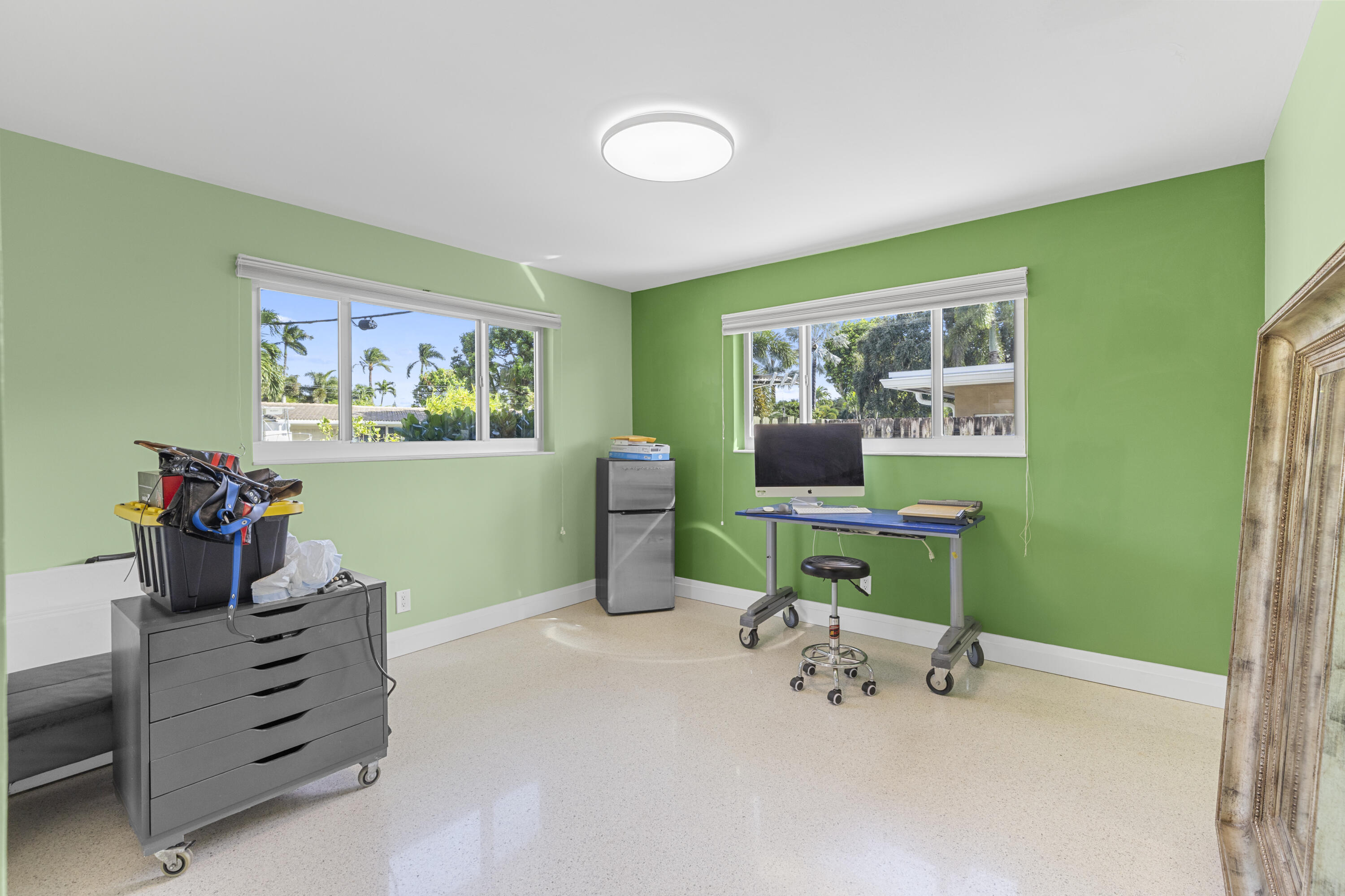 Room featuring polished terrazzo flooring, two large sliding windows, and a ceiling-mounted flush-mount light fixture