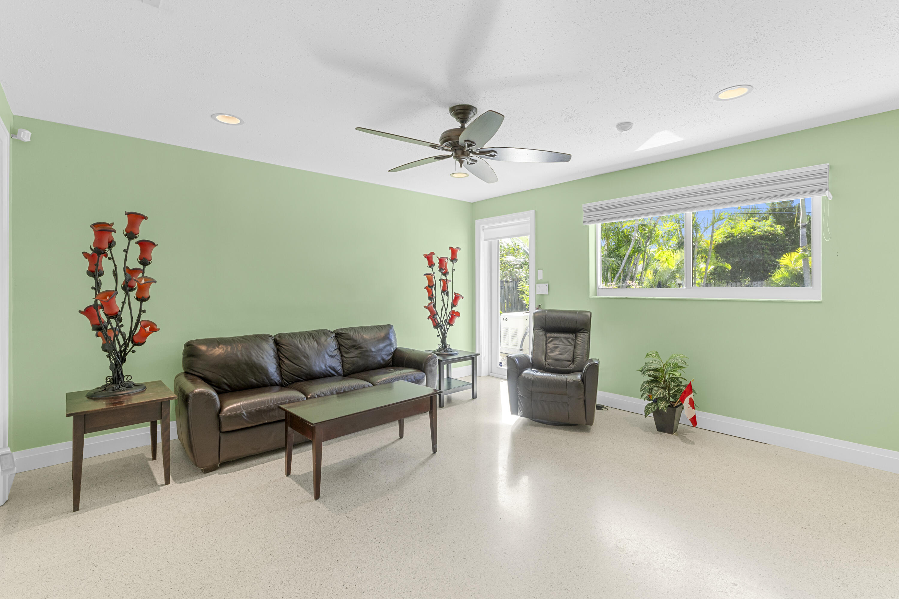 Interior space featuring polished concrete flooring, recessed lighting, a ceiling fan, and a wide horizontal window with an integrated blind