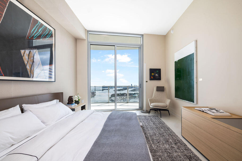 Floor-to-ceiling glass sliding door, balcony with metal railing, and neutral wall tones