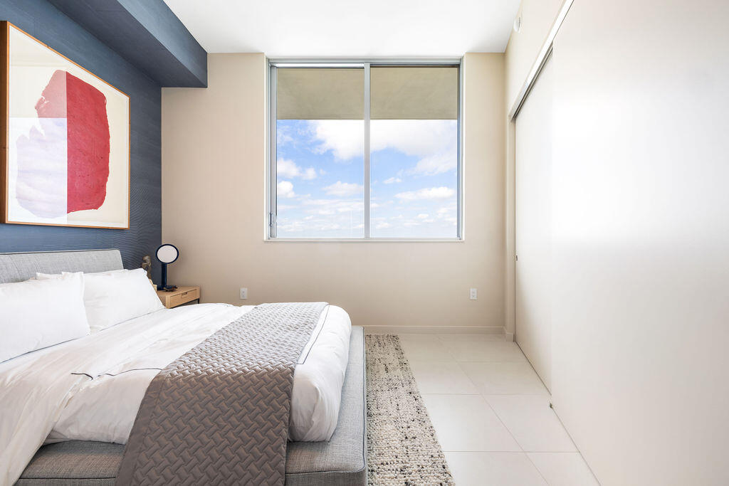 Floor-to-ceiling accent wall, large sliding window, and neutral tile flooring