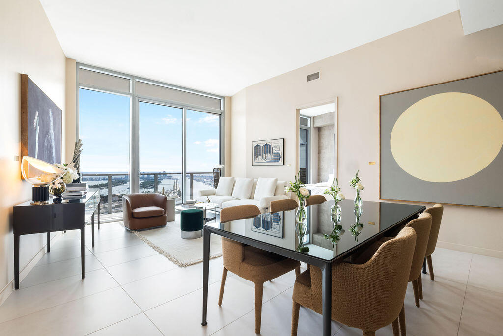 Open-concept living space featuring floor-to-ceiling windows, porcelain tile flooring, and a private balcony