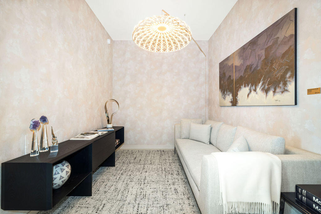 Textured neutral wall treatments, patterned wall-to-wall carpeting, and a geometric pendant light fixture