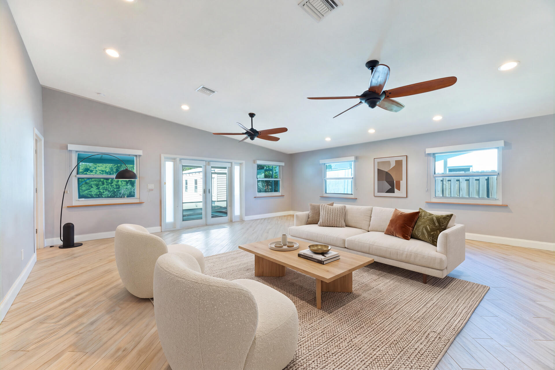 Open-concept room featuring ceramic plank flooring, recessed lighting, dual ceiling fans, and glass-paneled exterior doors