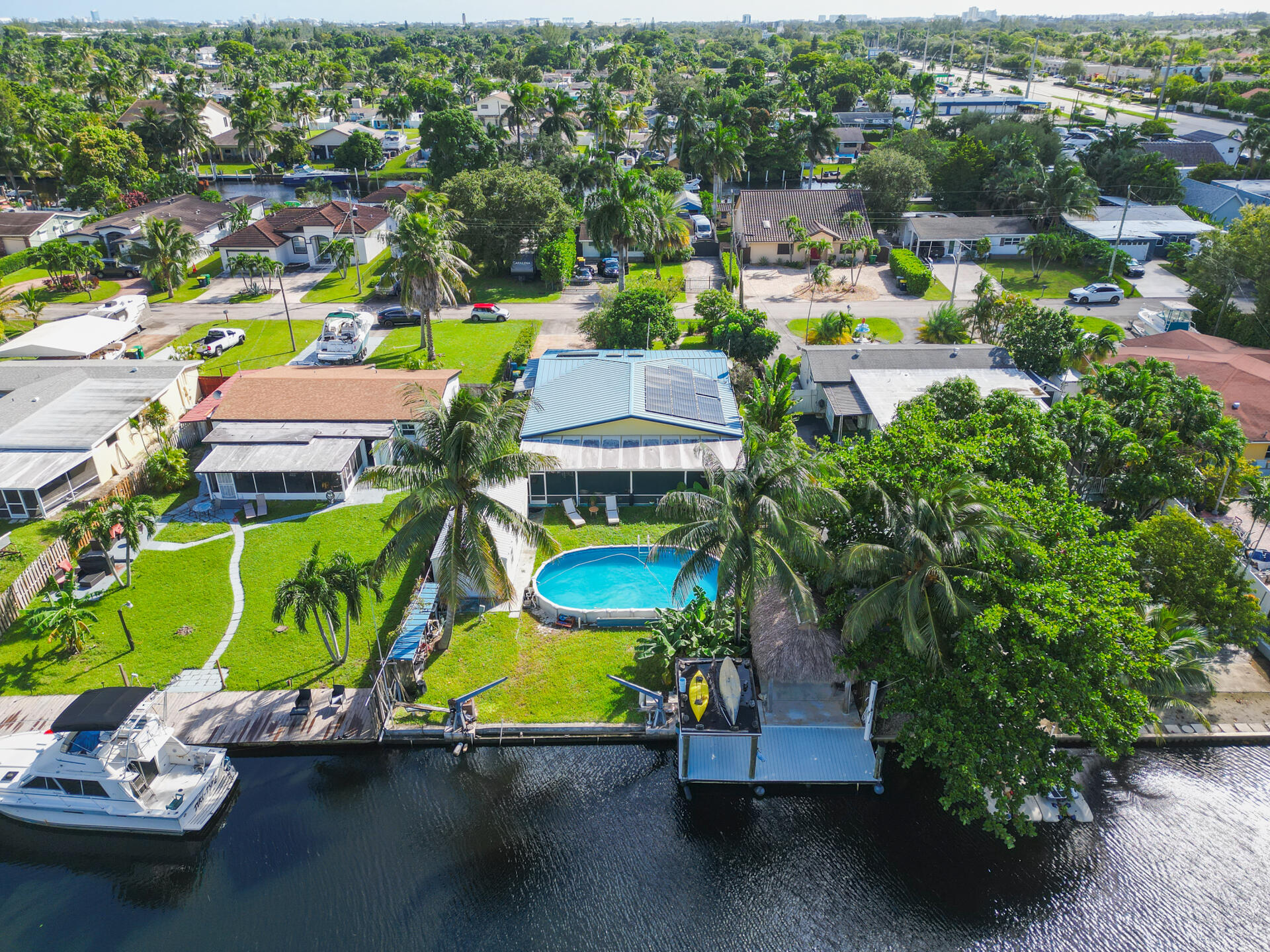 Waterfront property featuring a private boat dock, in-ground swimming pool, 28 solar panel array, and expansive canal frontage