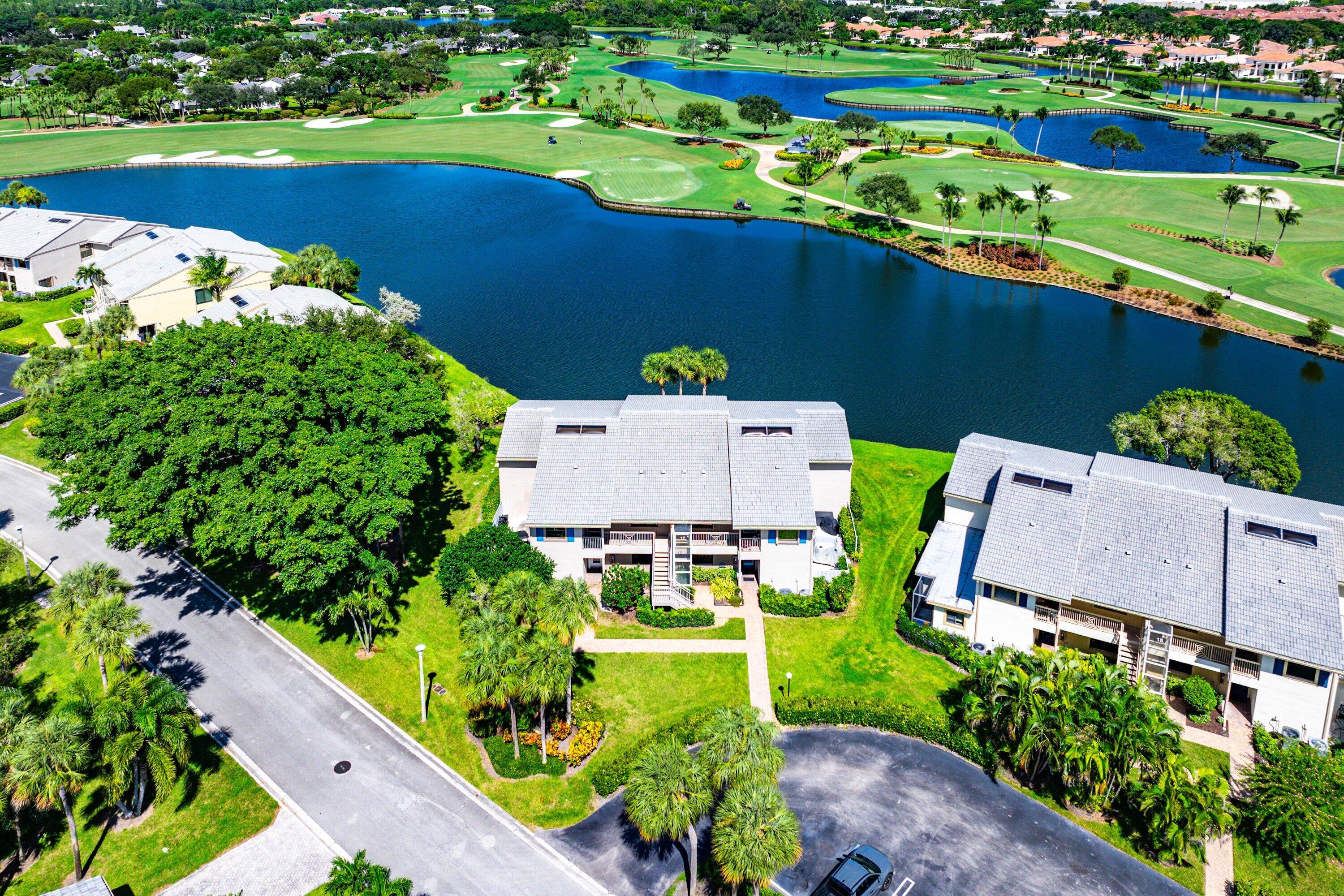 Multi-level residences featuring shingle roofing and mature landscaping situated on a water-frontage lot with direct golf course surroundings