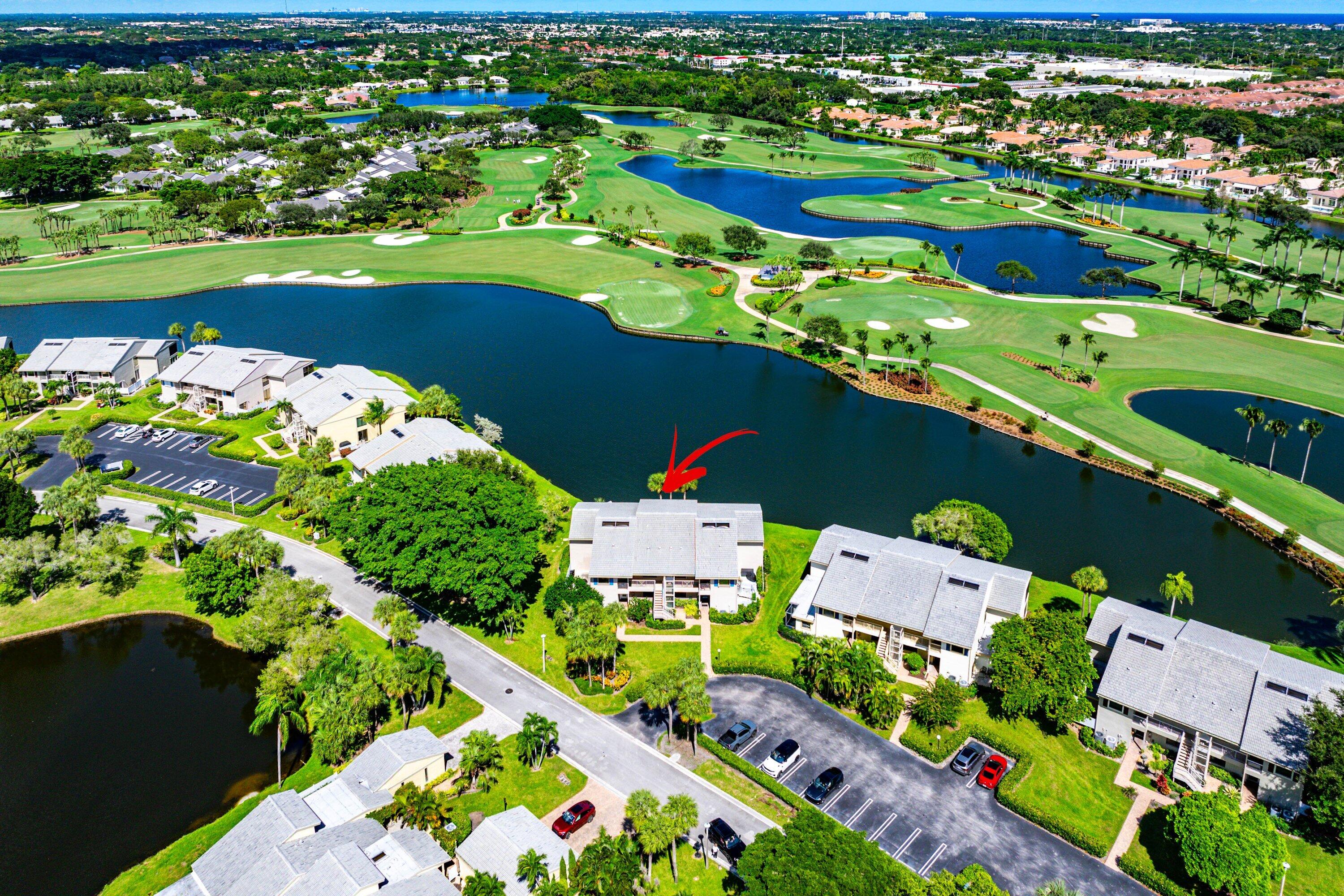 Aerial perspective of multi-story residence featuring waterfront positioning, expansive water features, and placement along a golf course