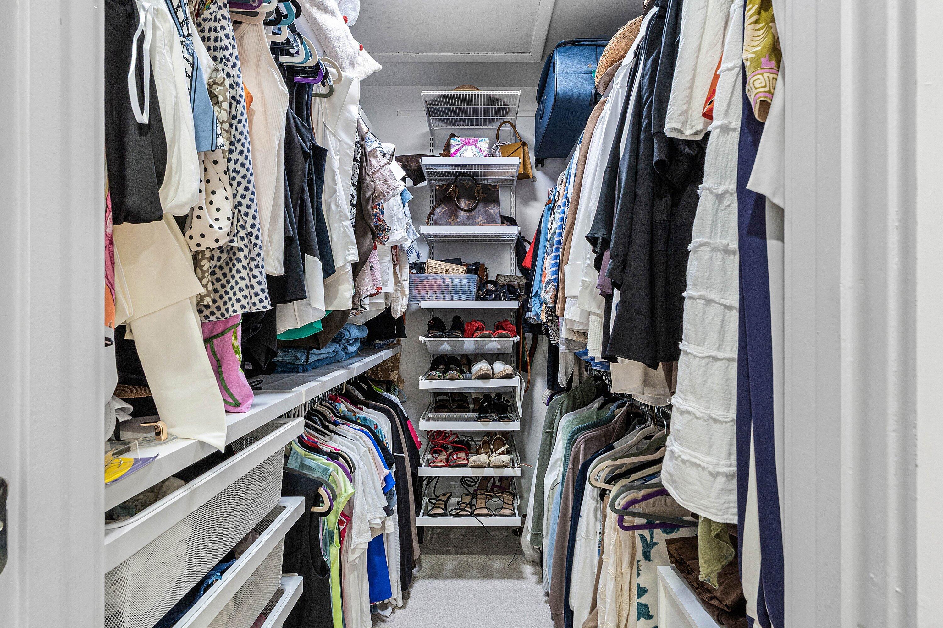 Walk-in closet featuring floor-to-ceiling adjustable shelving, integrated hanging rods, and pull-out wire drawers