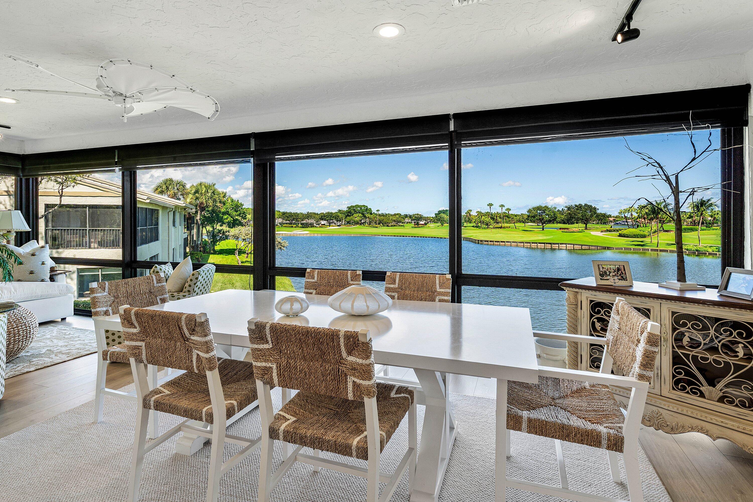 Floor-to-ceiling windows with black framing, wood-finish flooring, recessed lighting, and water backdrop Floor-to-ceiling windows with black framing, wood-finish flooring, recessed lighting, and water backdrop