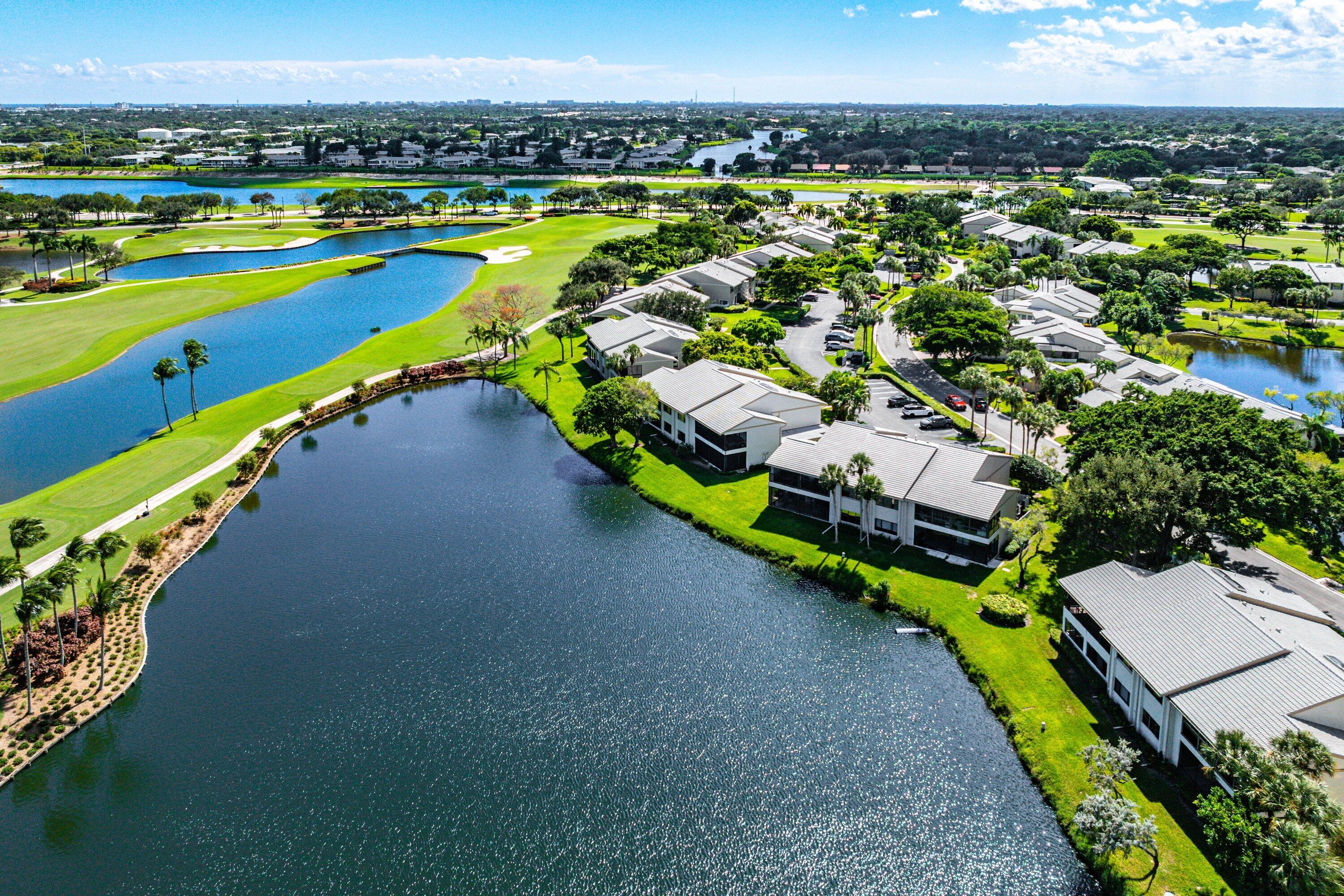 Aerial perspective of waterfront properties featuring manicured landscaping, mature trees, and proximity to golf course fairways