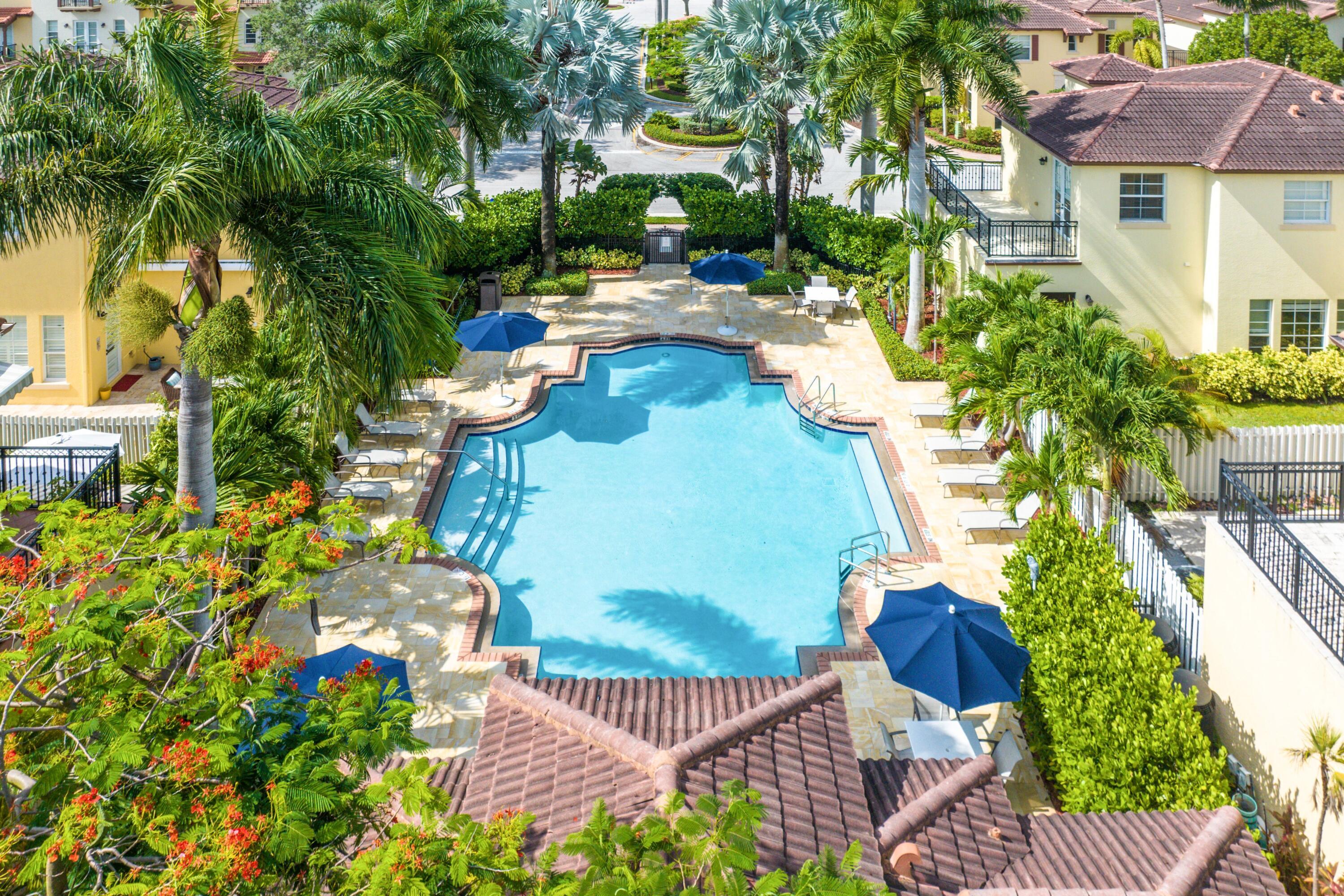 Sparkling community pool with spacious sun deck and lush greenery.