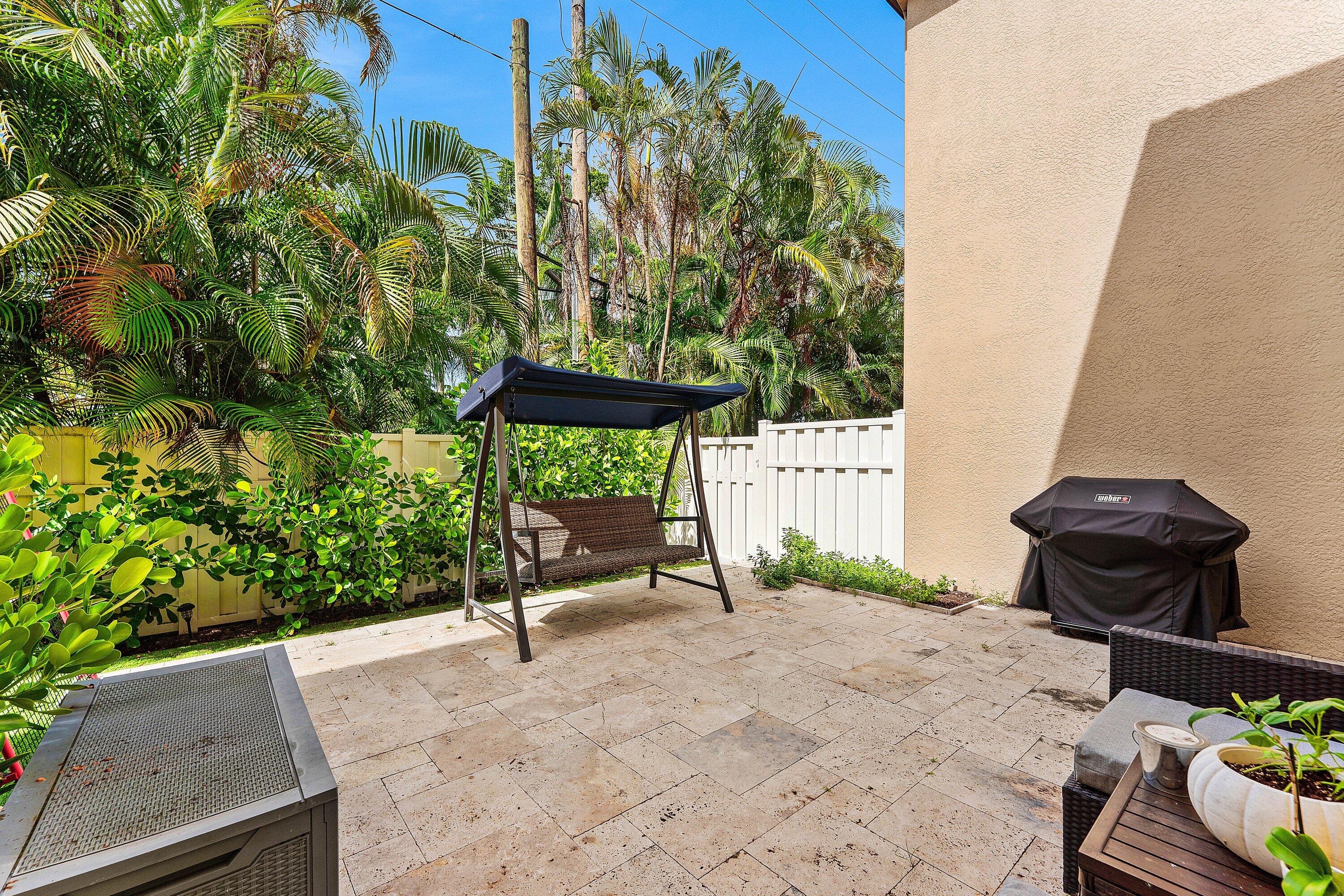 Spacious paved patio surrounded by lush tropical landscaping