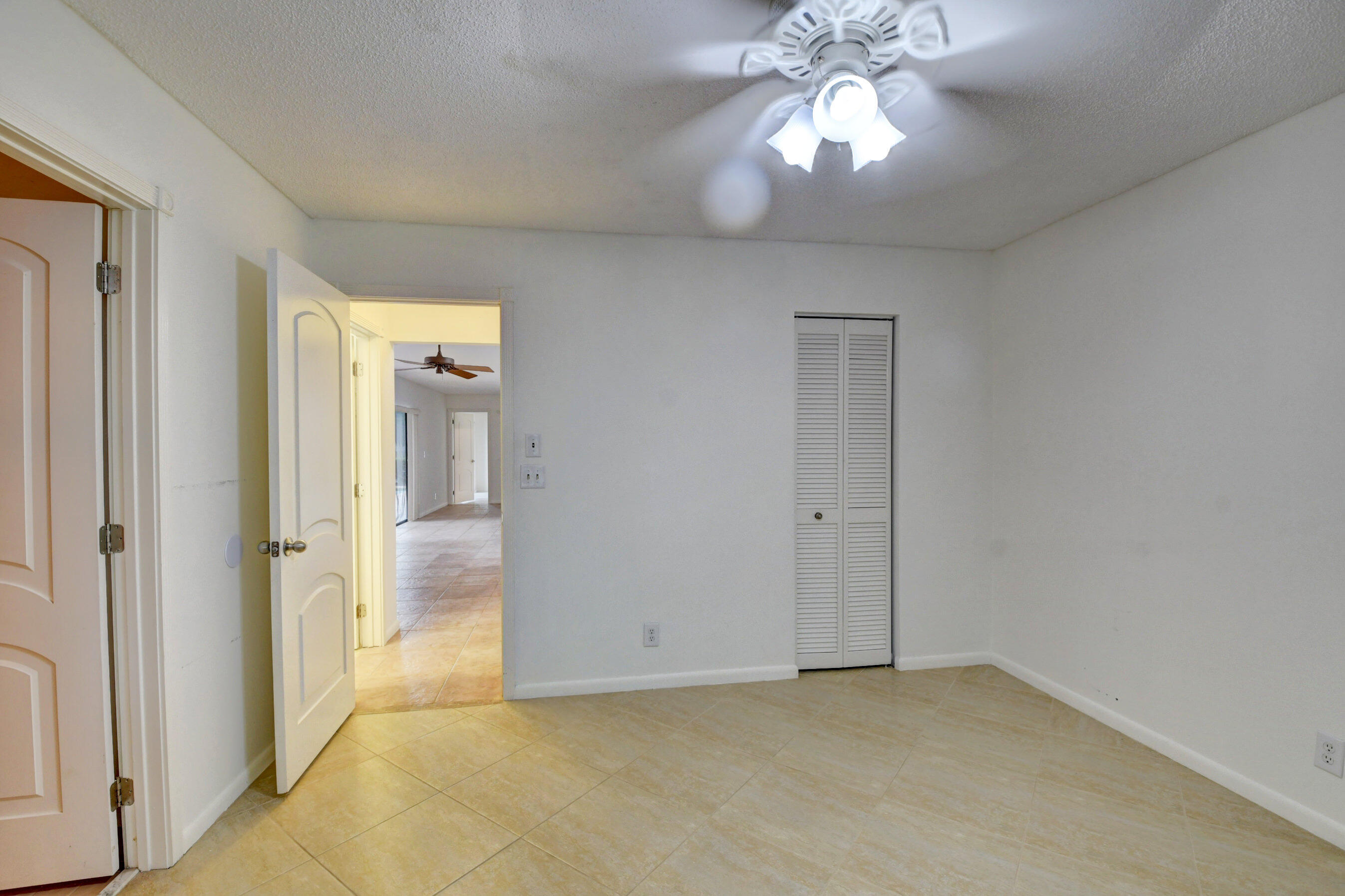 Bright & Inviting Bedroom with Ceiling Fan, Neutral Finishes & Natural Light
