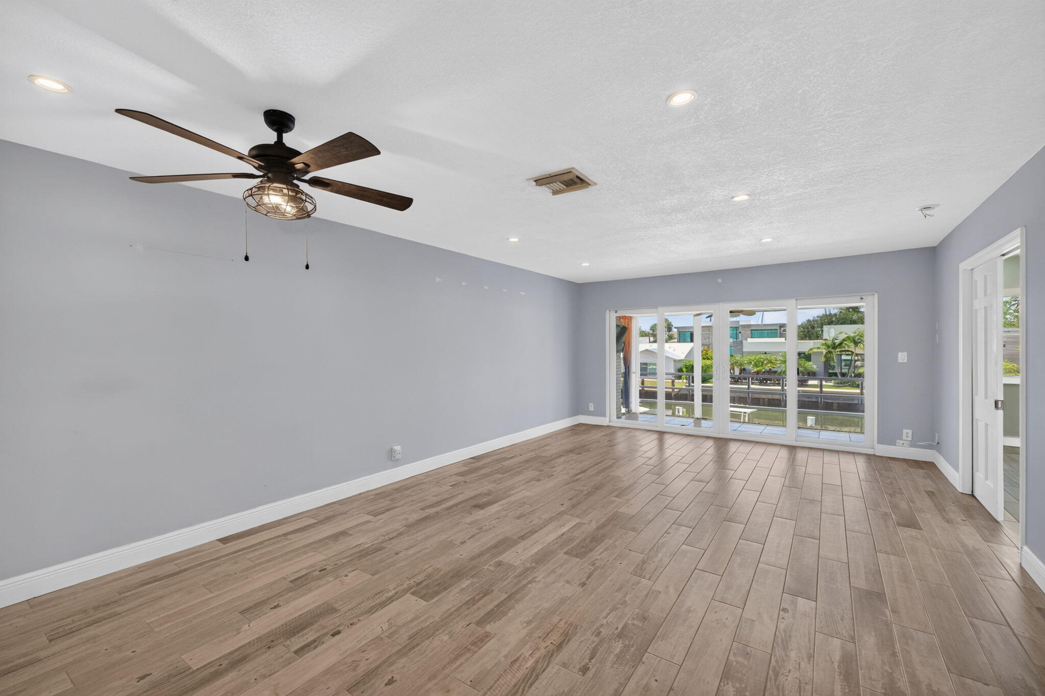 Wood-finish flooring, recessed lighting, and a ceiling fan with integrated lighting