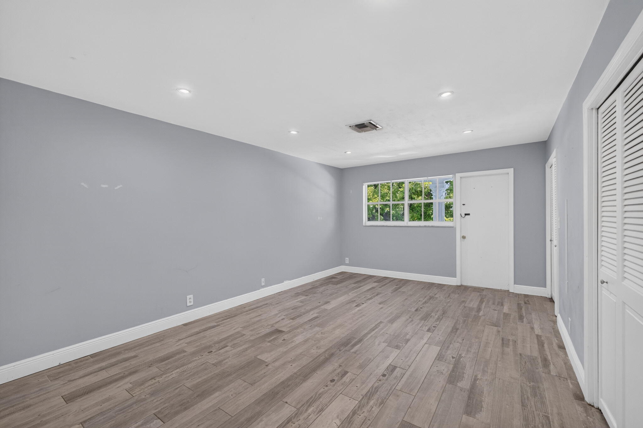 Wood-finish flooring, recessed lighting, and a window with exterior views