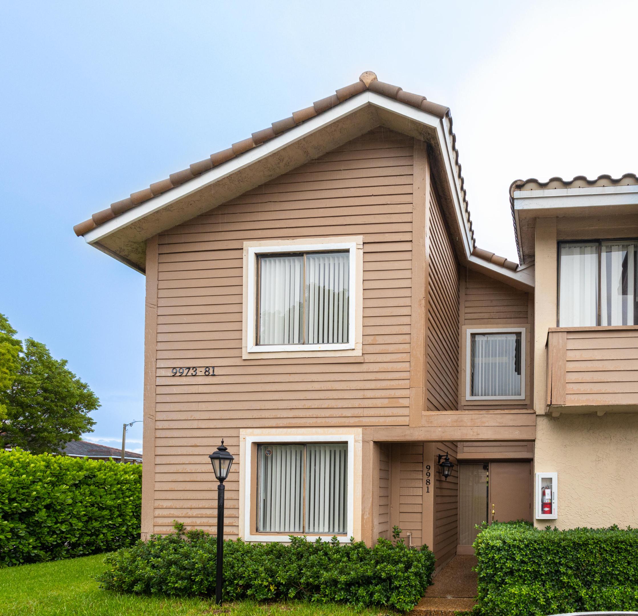 Stucco exterior with horizontal siding, tile roof, and manicured shrubbery Stucco exterior with horizontal siding, tile roof, and manicured shrubbery
